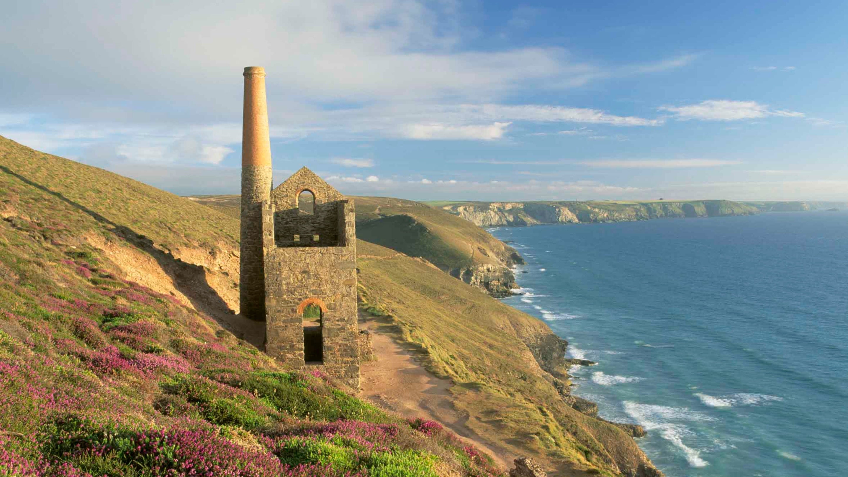 A ruinous engine house perched on cliffs at St Agnes Head, with the sea to the right