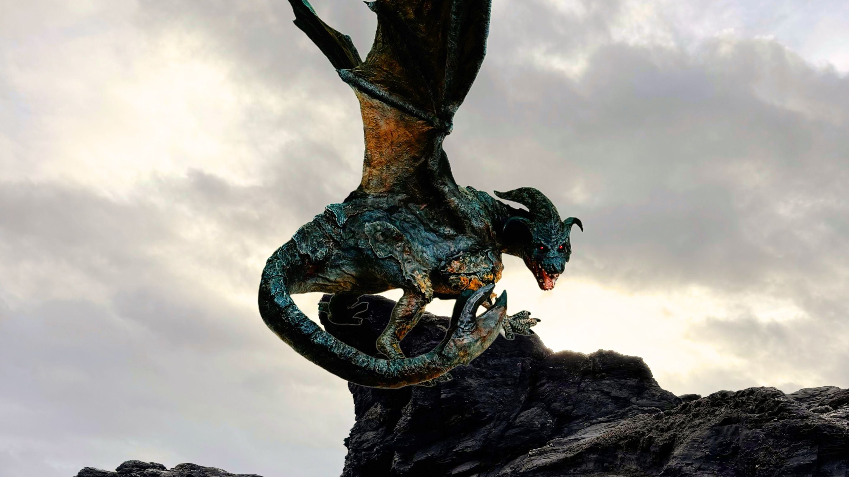 A terrifying 15 foot Cornish dragon perched on a rock and looking scarily at the camera