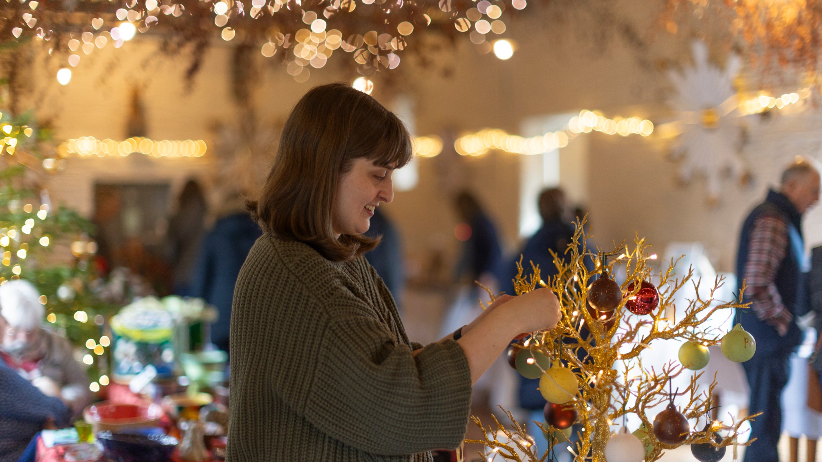 A visitor admires decorations for sale on a stand in a craft fair