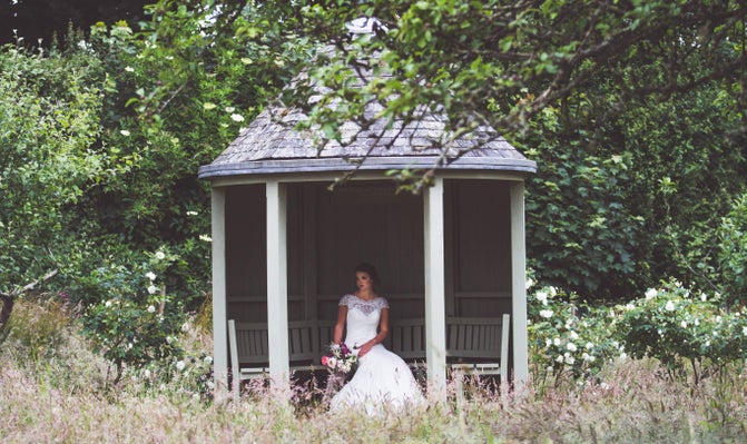 A bride is pictured sat in the summerhouse at Trerice