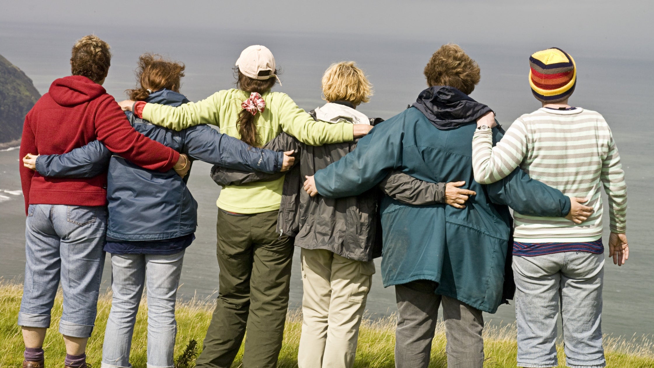 Group of volunteers taking in the view on a clifftop, on a National Trust Working Holiday on Exmoor near Lynmouth, North Devon