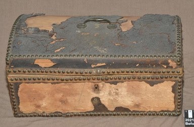 A small 18th century travelling trunk, pictured before conservation with significant losses to the leather, A la Ronde, Devon.