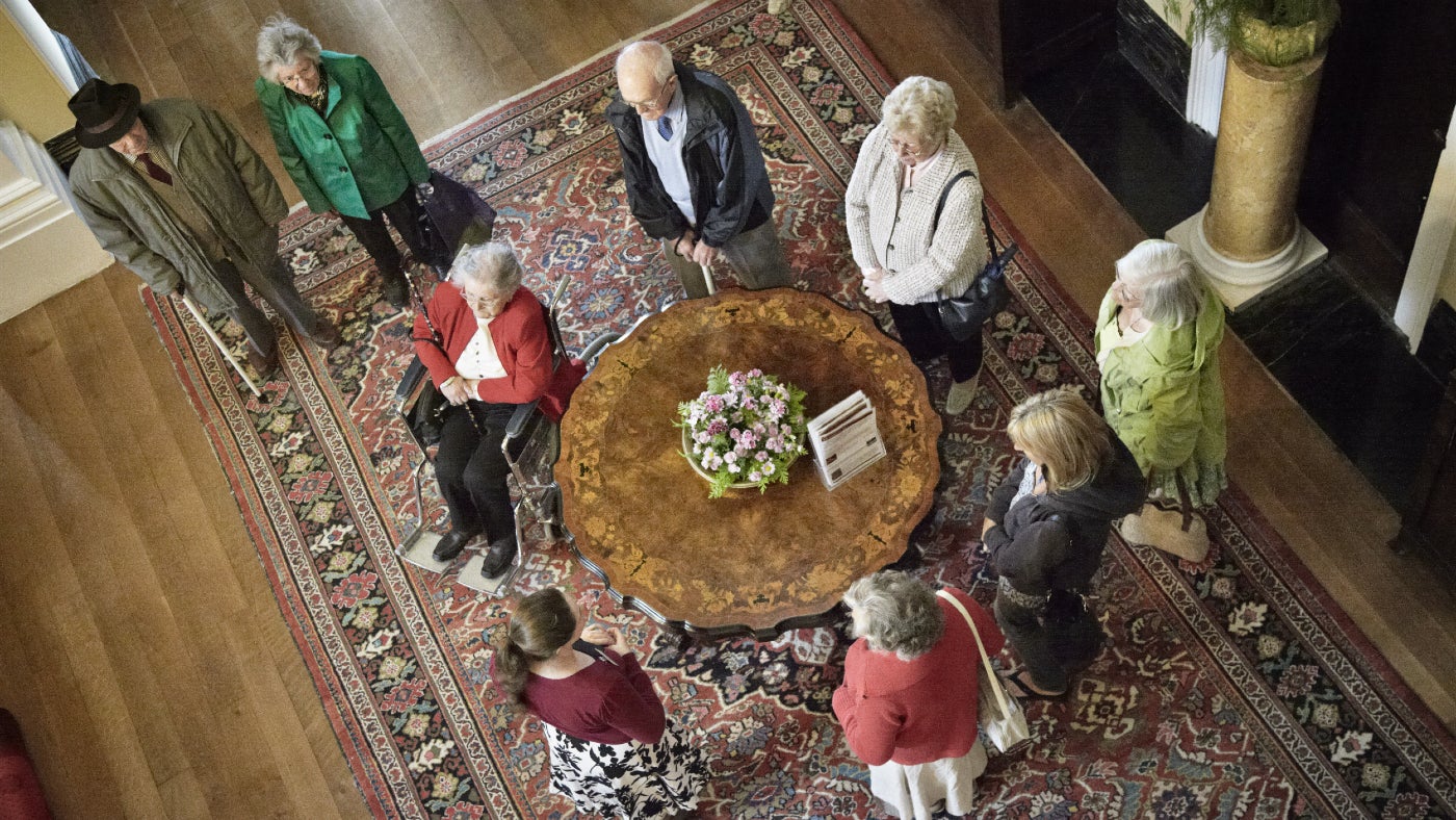 A group gathers around a table during a tour of the house at Arlington Court