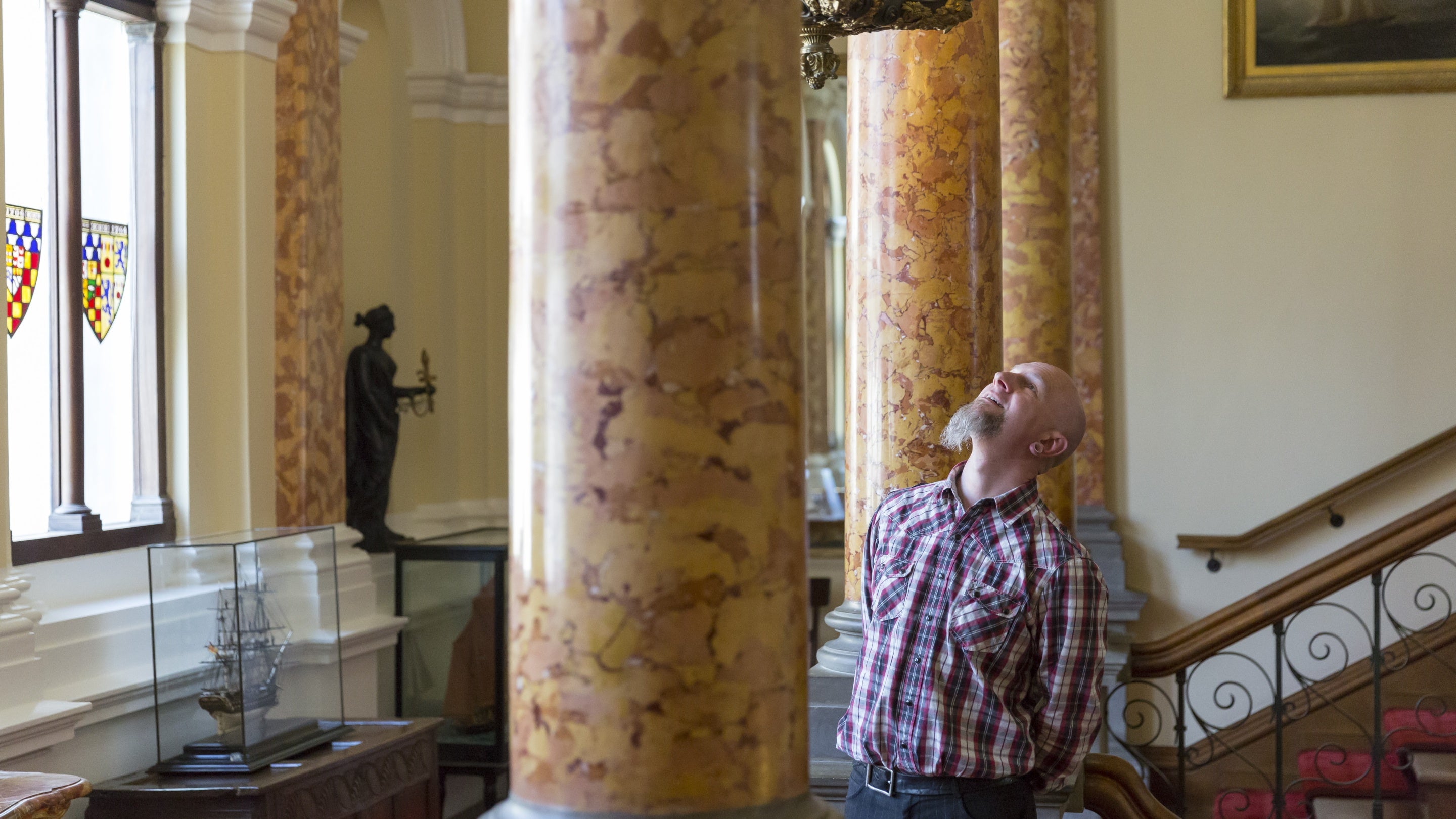 Visitor in the Staircase Hall at Arlington Court, Devon