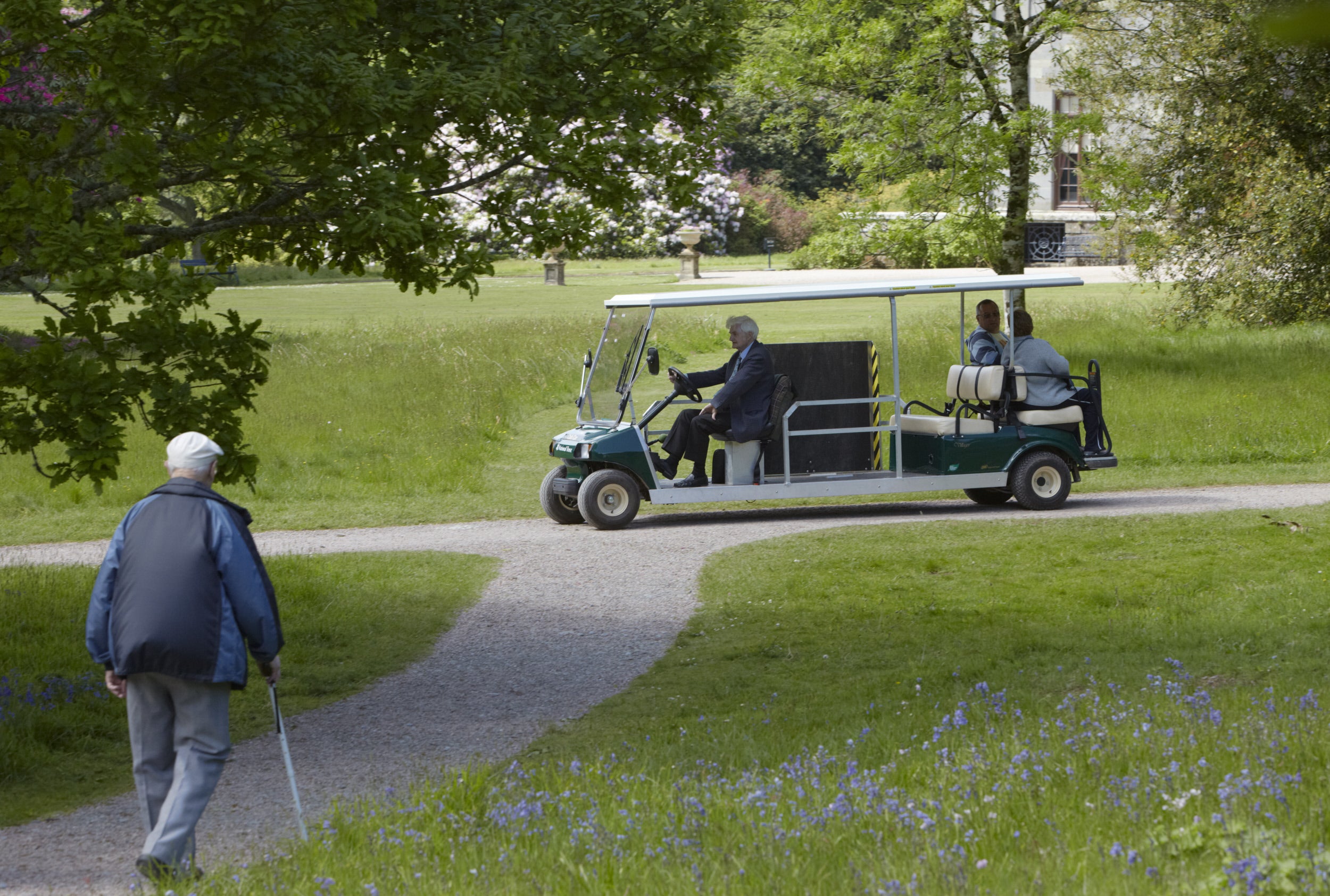 The visitor buggy at Arlington Court driving along the path in front of the main house at Arlington Court, Devon.
