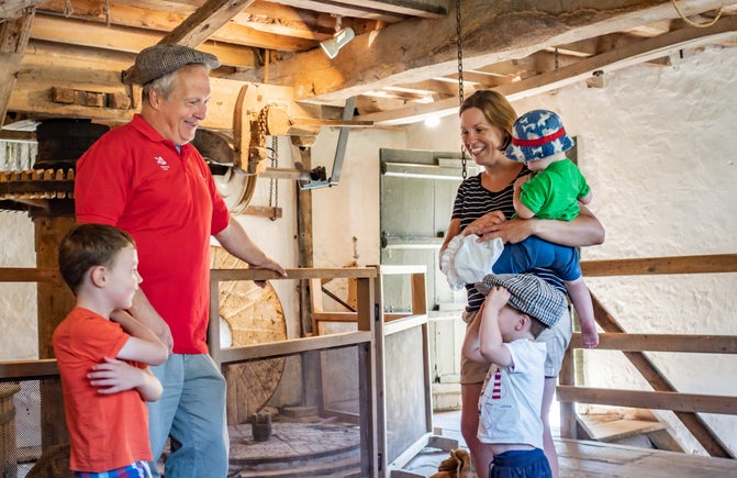 mum with her young children talking to a volunteer guide inside manor mill