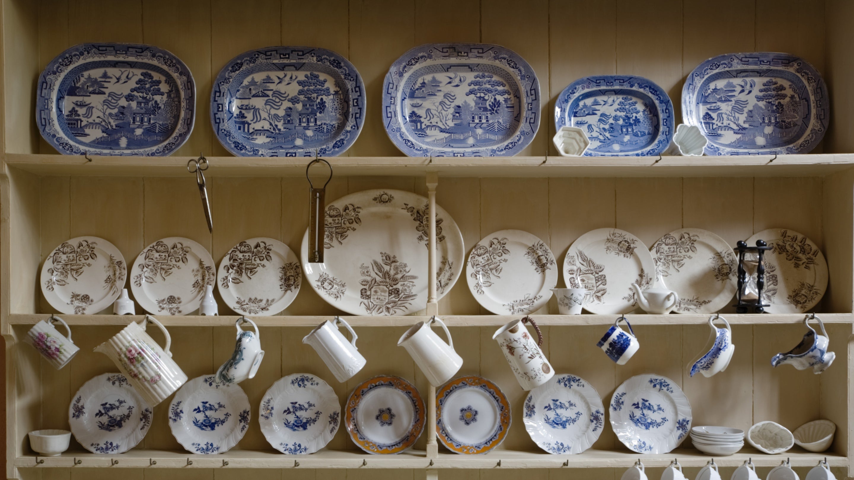 Blue and white china hanging on a dresser in the kitchen at Buckland Abbey