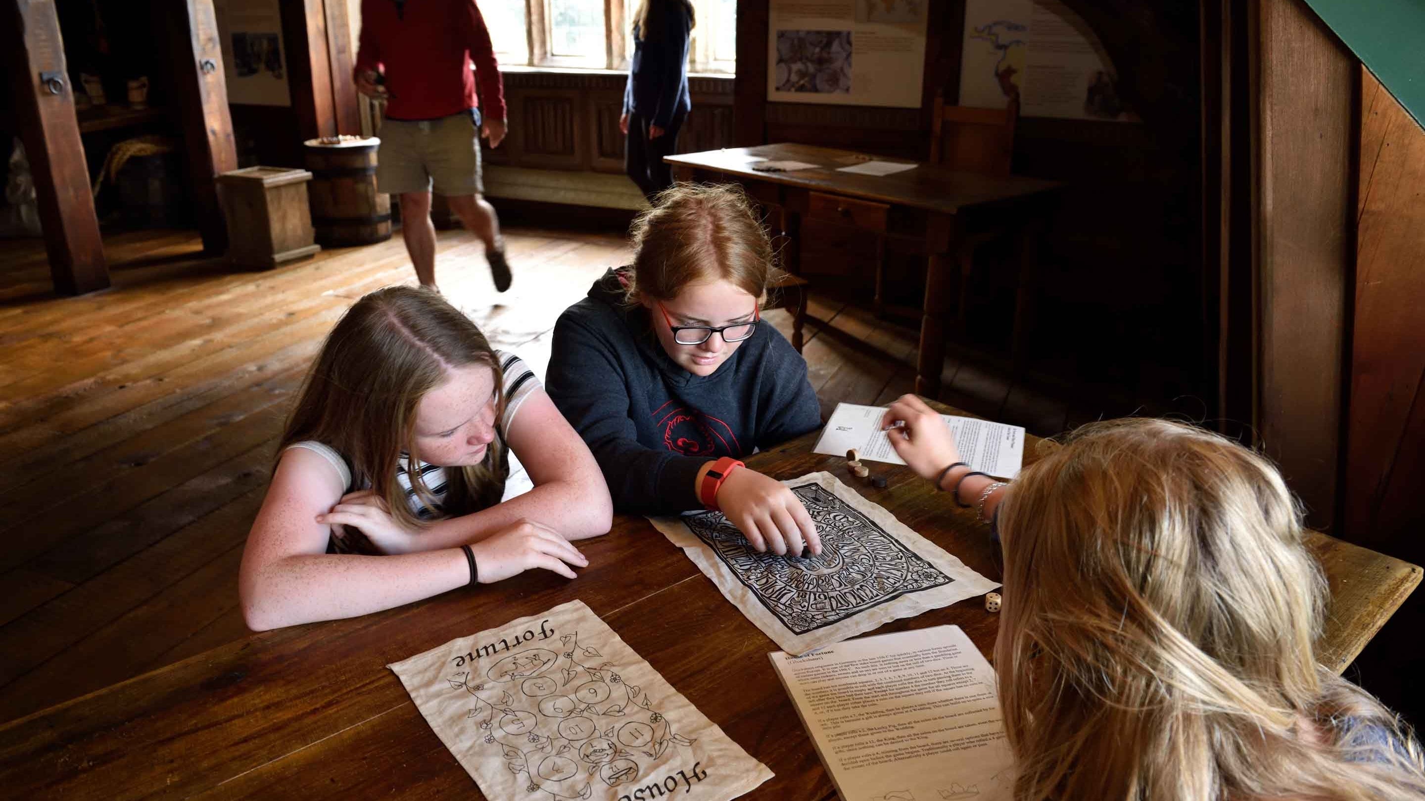 Young visitors playing board games at Buckland Abbey, Devon