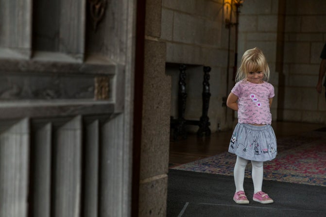 A child stood enjoying the entrance hall at Castle Drogo with the front door in the foreground.