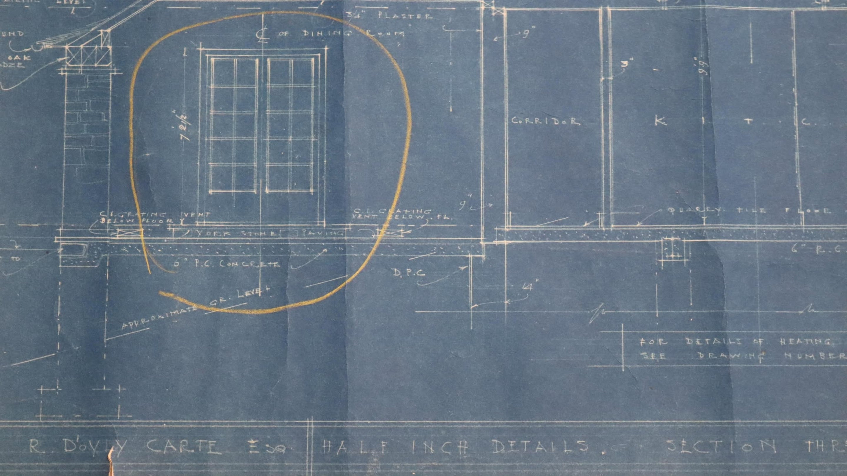 Archive blueprint detailing a window design with measurements and annotations, framed in a circular highlight on a blue background.