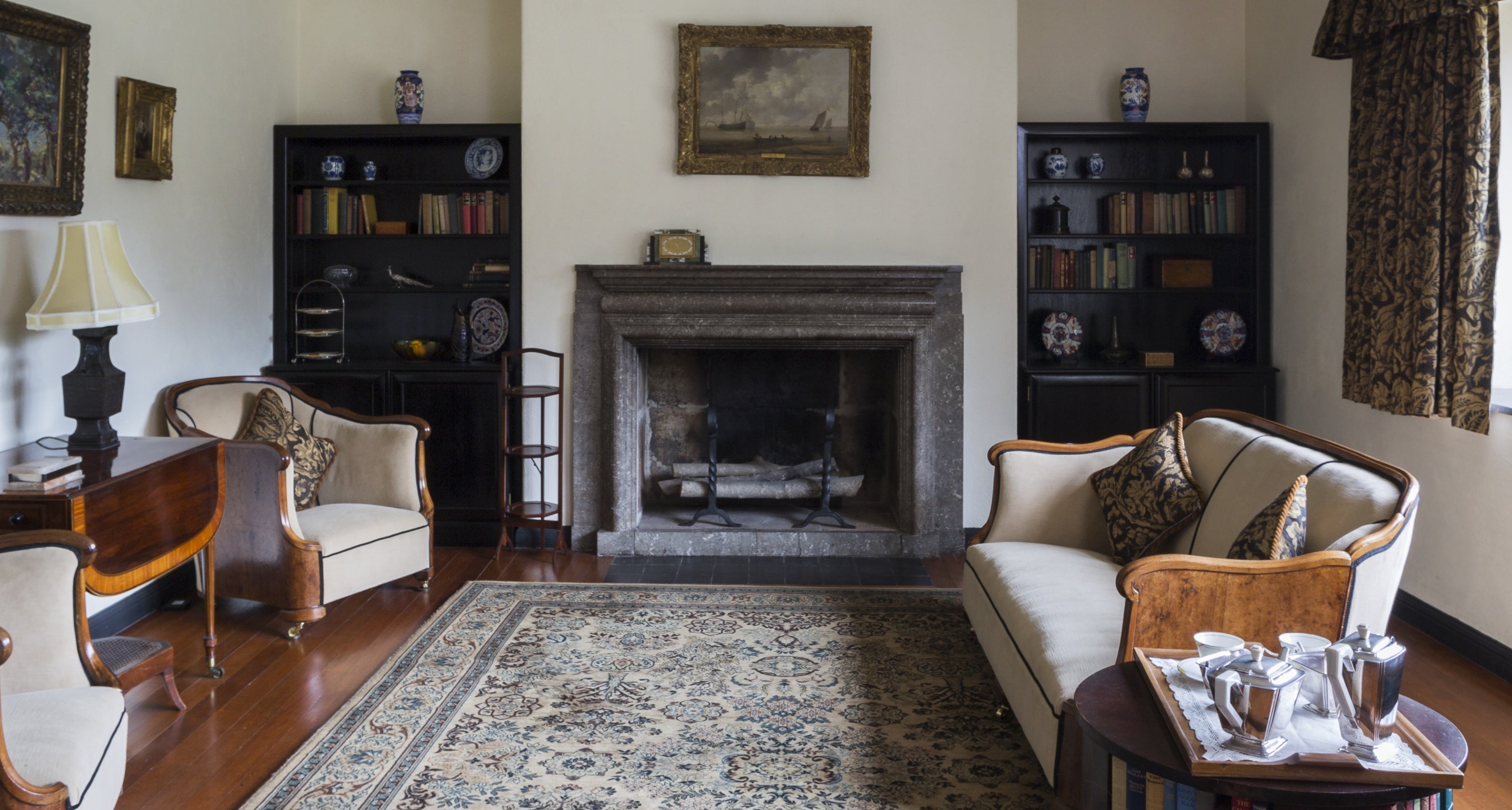 The Sitting Room at Coleton Fishacre, Devon, featuring the limestone fireplace