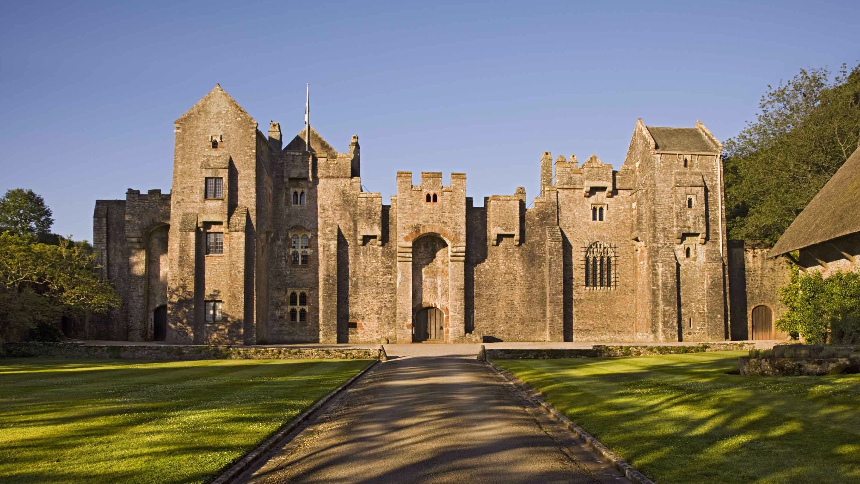 The north front of Compton Castle, Devon, covered by shadows from trees