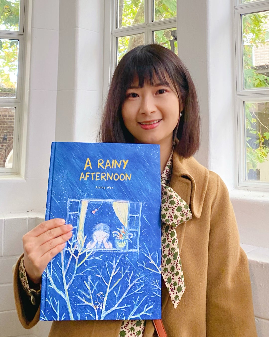 Writer Aining Wen and one of her illustrated children's books