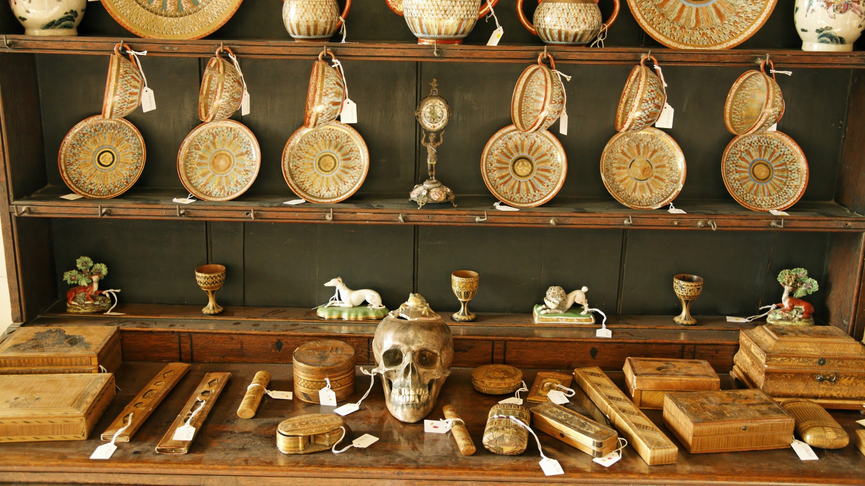 A dresser covered in collection items including a skull jar at Greenway in Devon