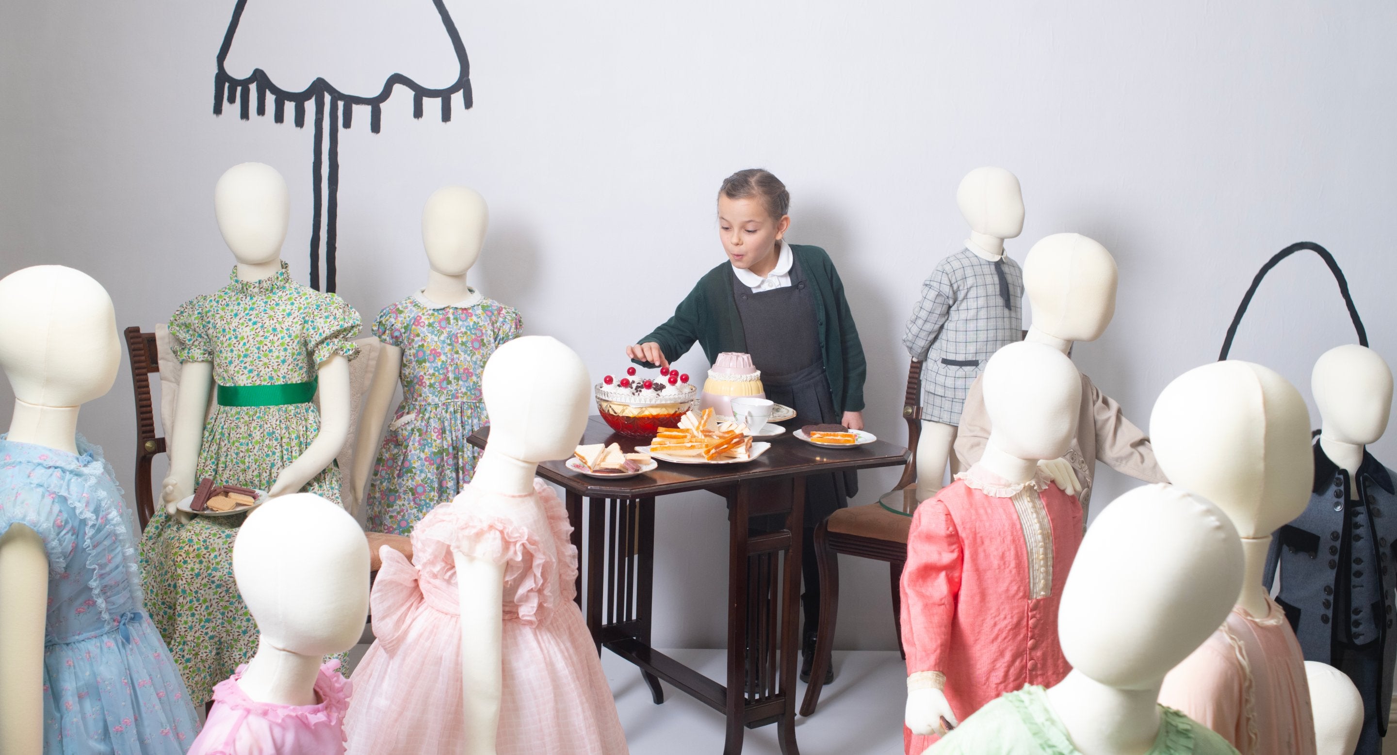 Tilly amongst dressed mannequins for Killerton's 2024 fashion exhibition