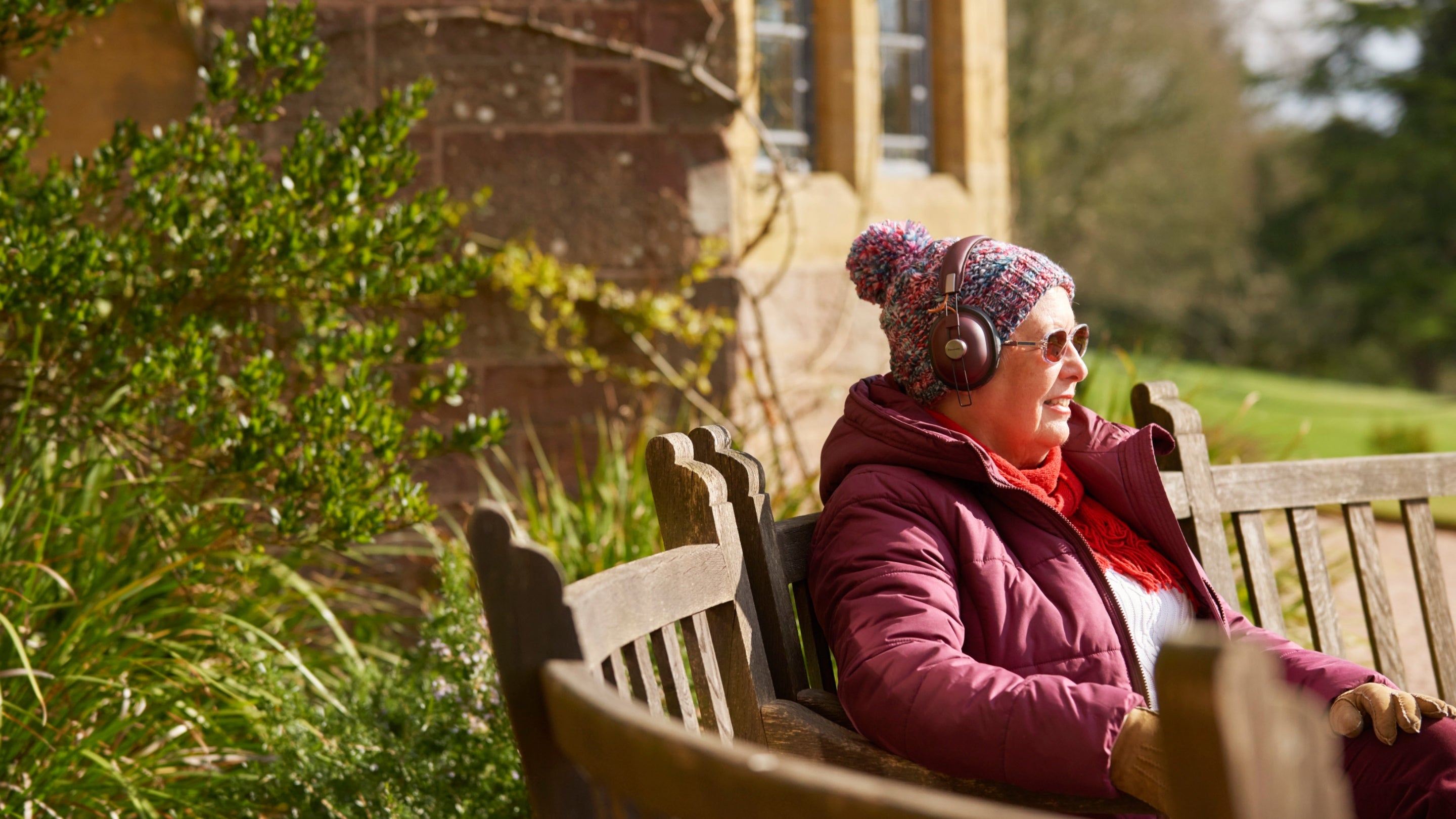 A visitor listens on headphones at Knightshayes, Devon
