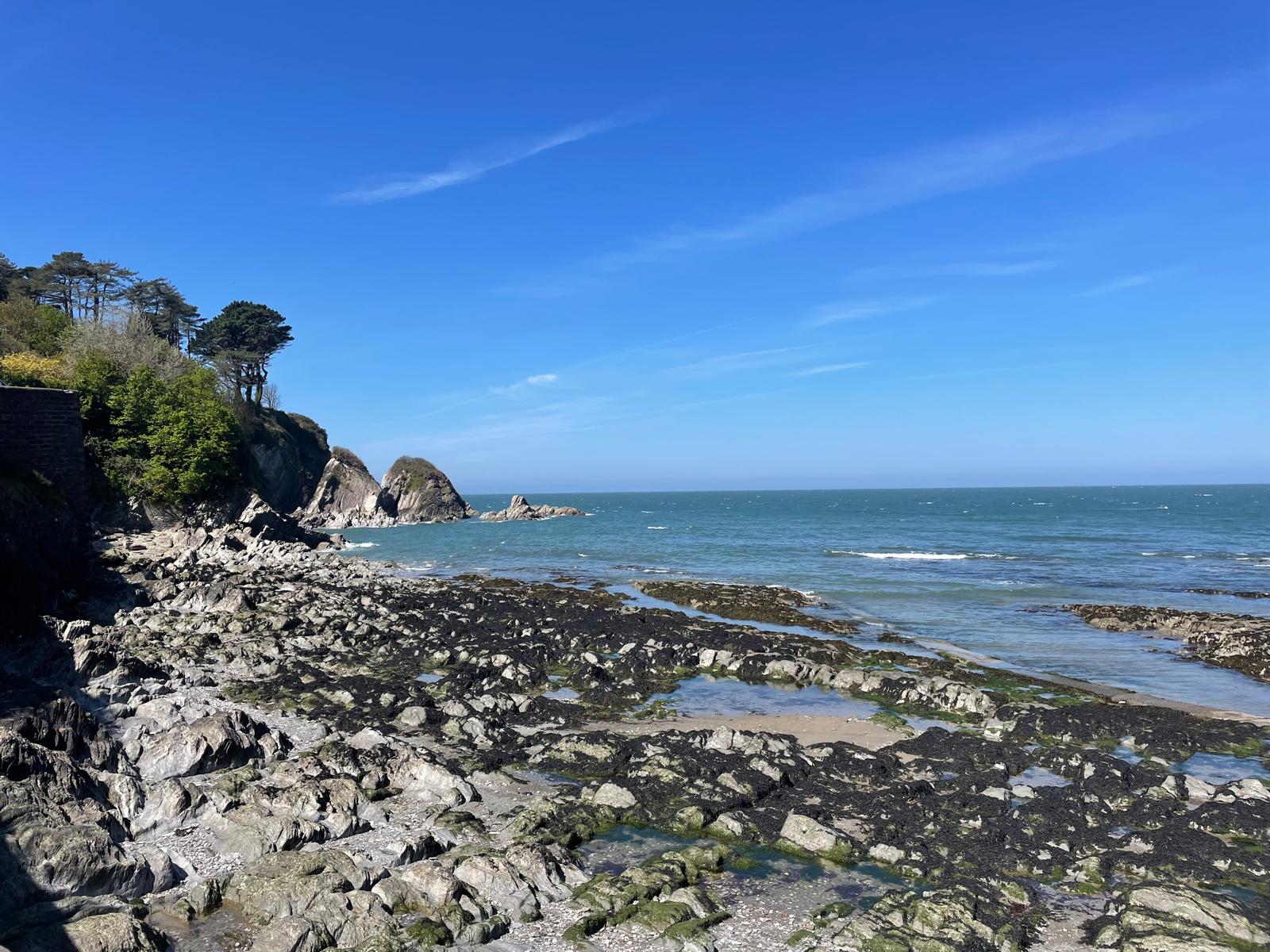 Over looking a bay with a low tide and exposed rockpools on the beach