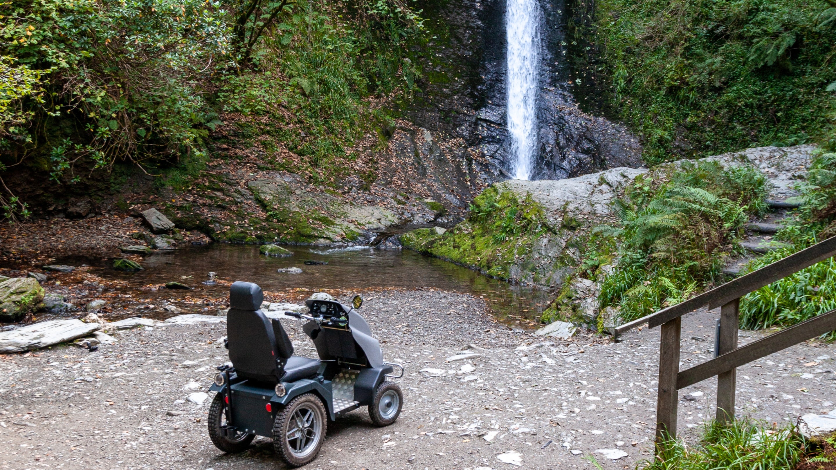 The all-terrain mobility Tramper in front of Whitelady Waterfall at Lydford Gorge, Devon