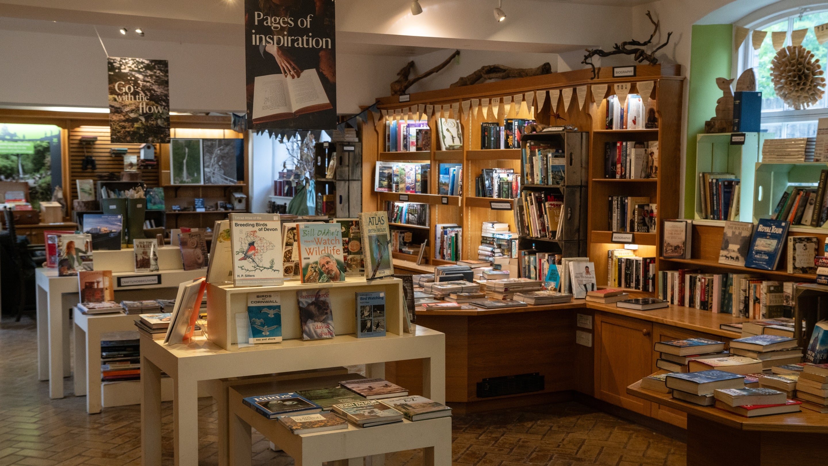 A view into the second-hand bookshop at Lydford Gorge with tables and shelves loaded with a wide range of books
