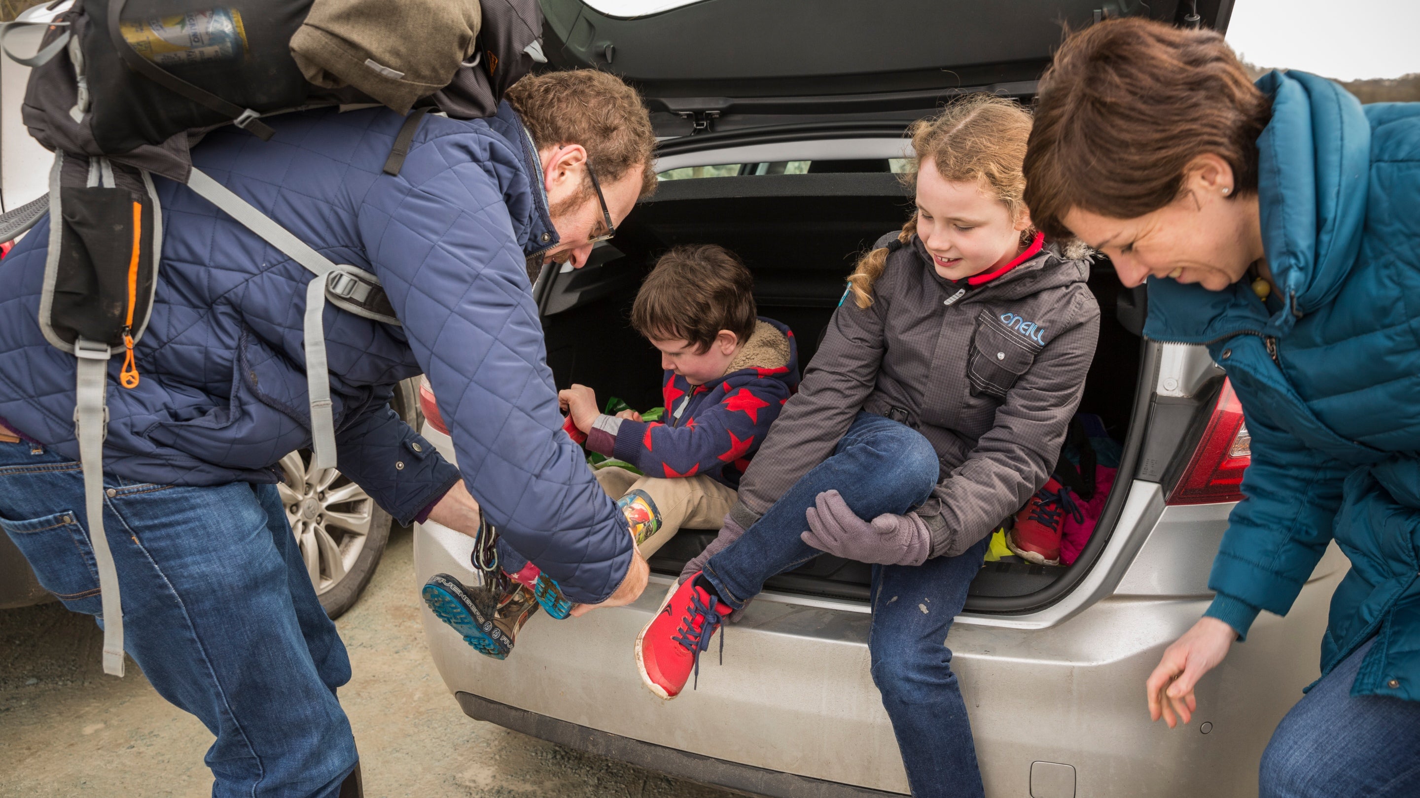 A family return to their car after exploring a trail