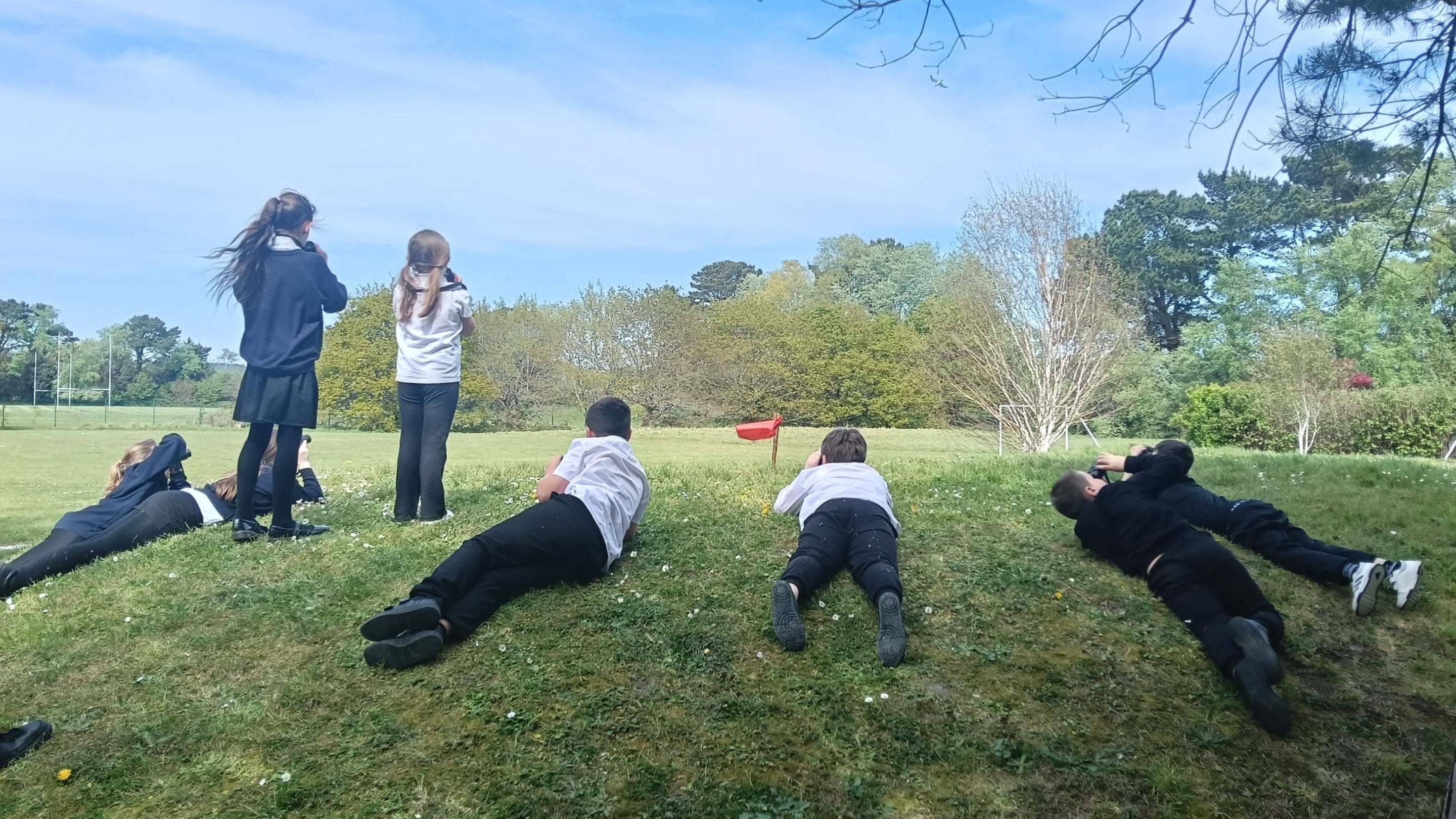 Children from Bayside Academy in Poole watching the birds through binoculars.
