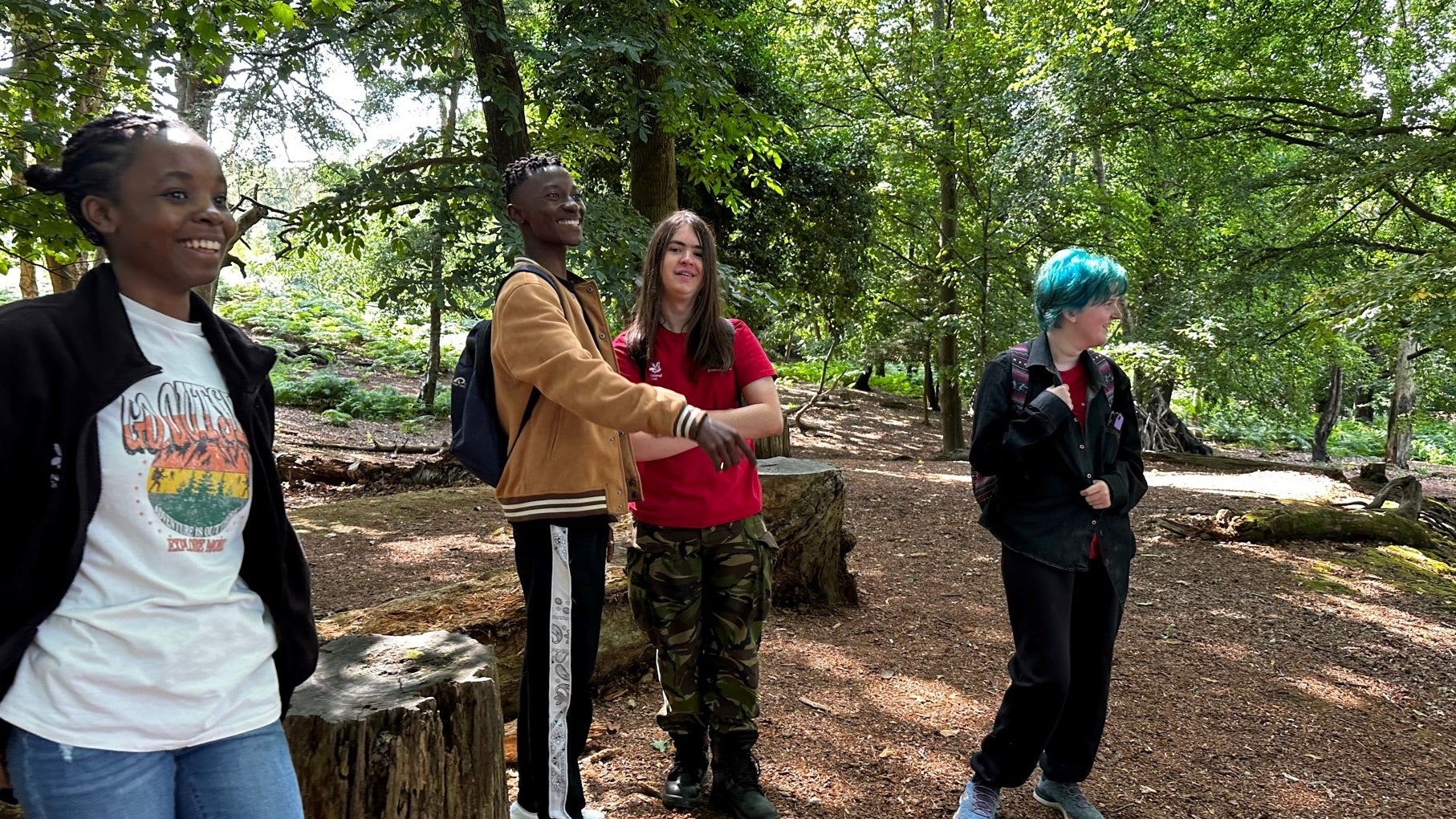 A group of four young adults from the Up programme standing in woodlands on Brownsea Island.