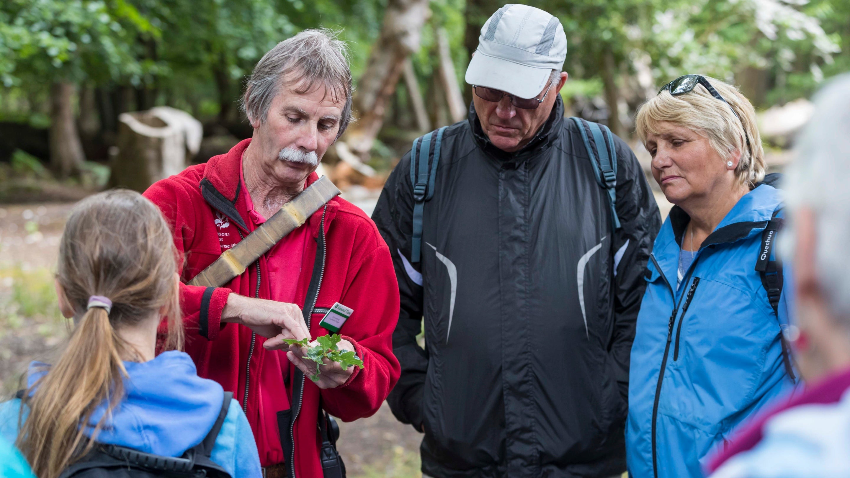 Visitors listen to a staff member on a guided nature walk on Brownsea Island, Dorset