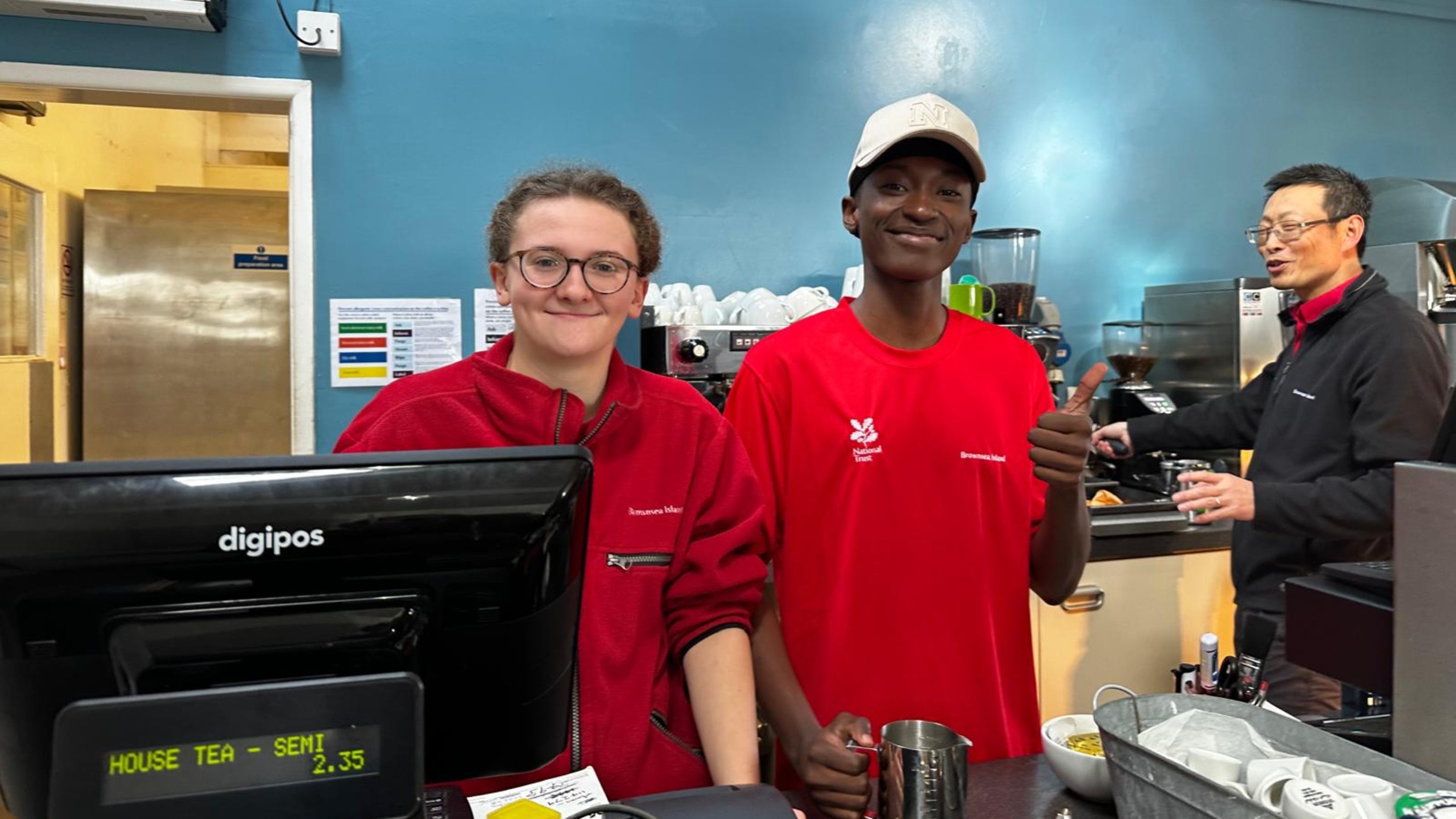The Brownsea Café team showing their work experience team member how to make coffee.
