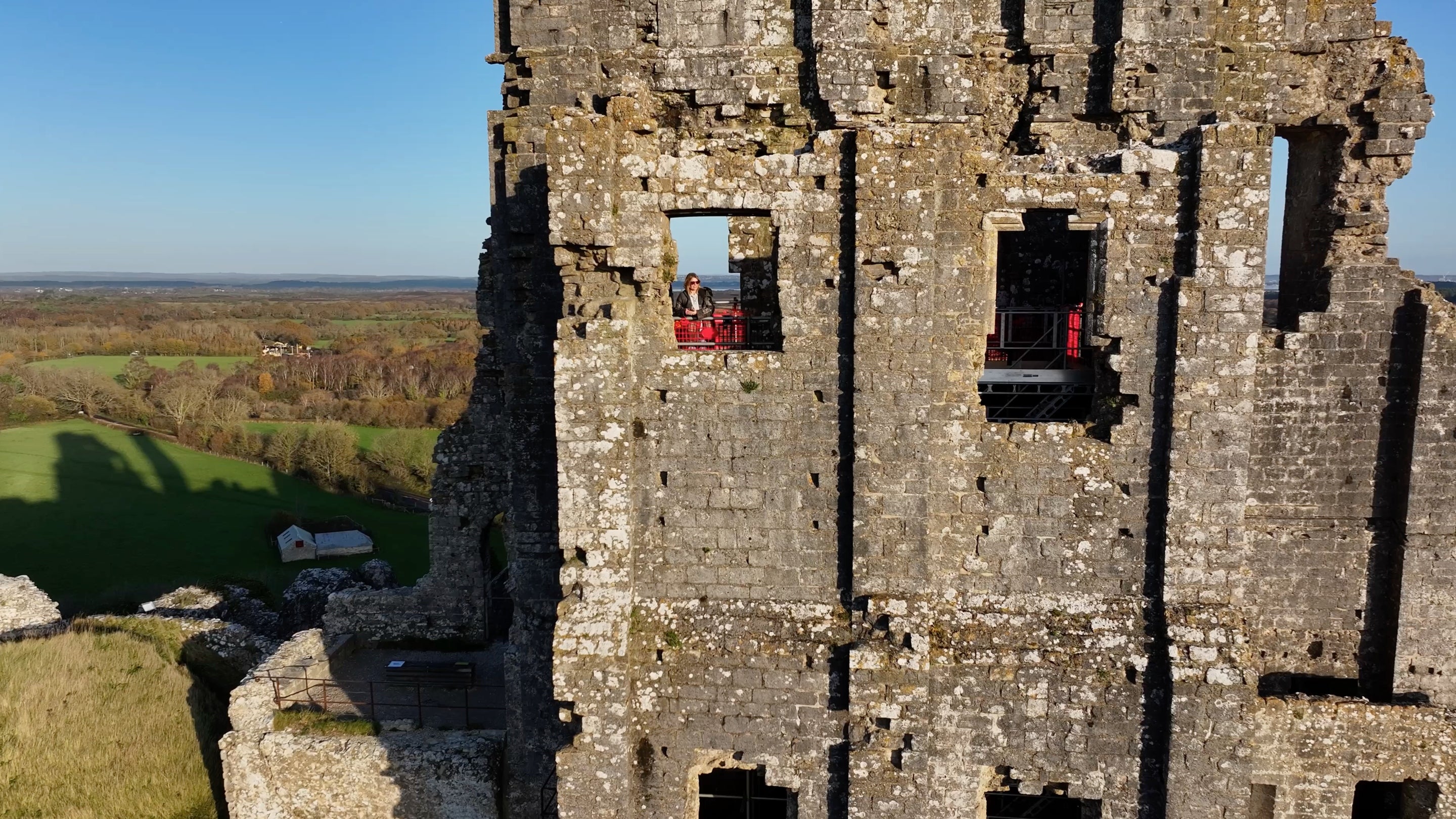 Visitor waving from the Kings' View high within Corfe Castle