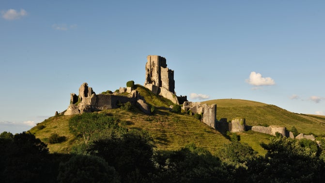 The medieval ruins of Corfe Castle on a hill on a sunny day in Dorset
