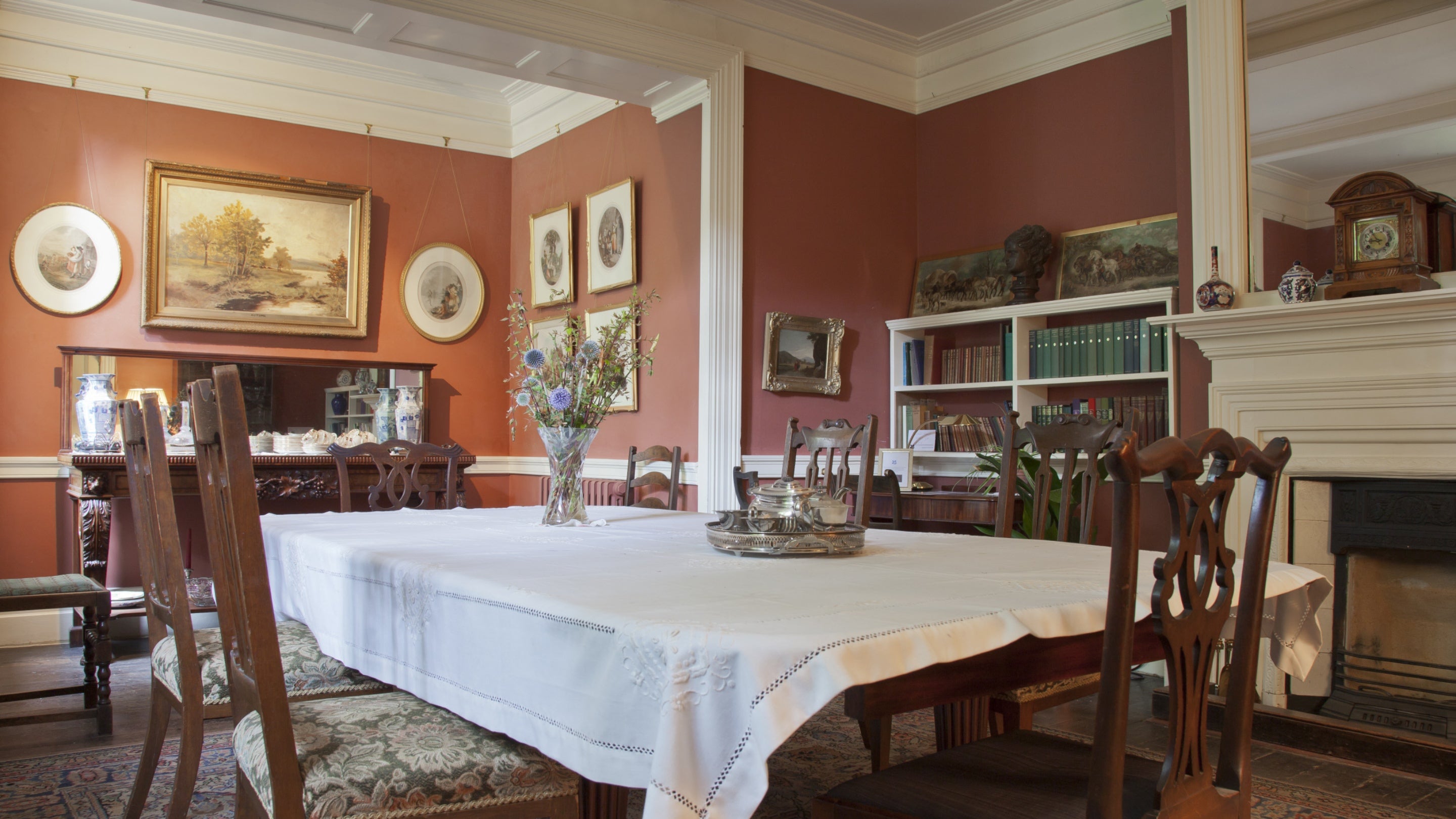 The dining room at Max Gate, with terracotta walls and a large dining table