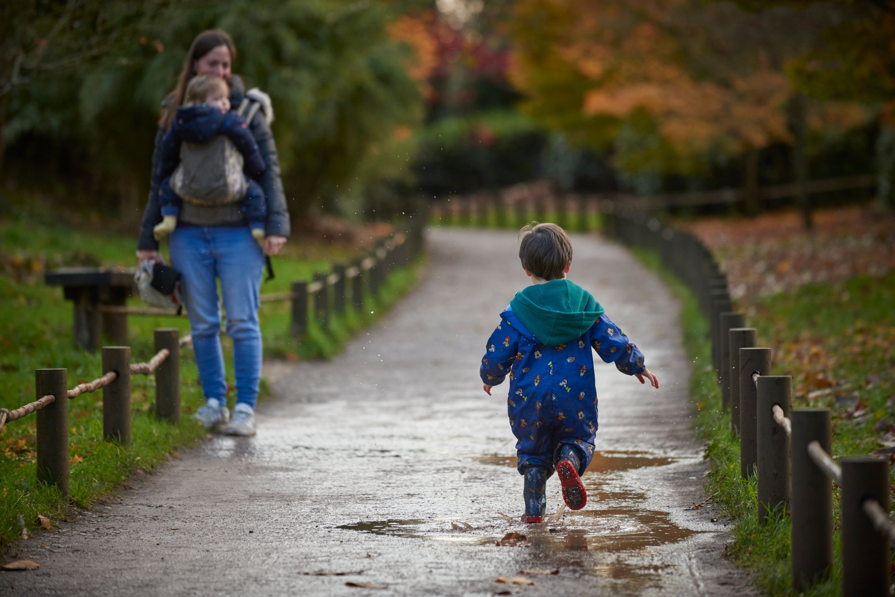 A child running along a path through puddles
