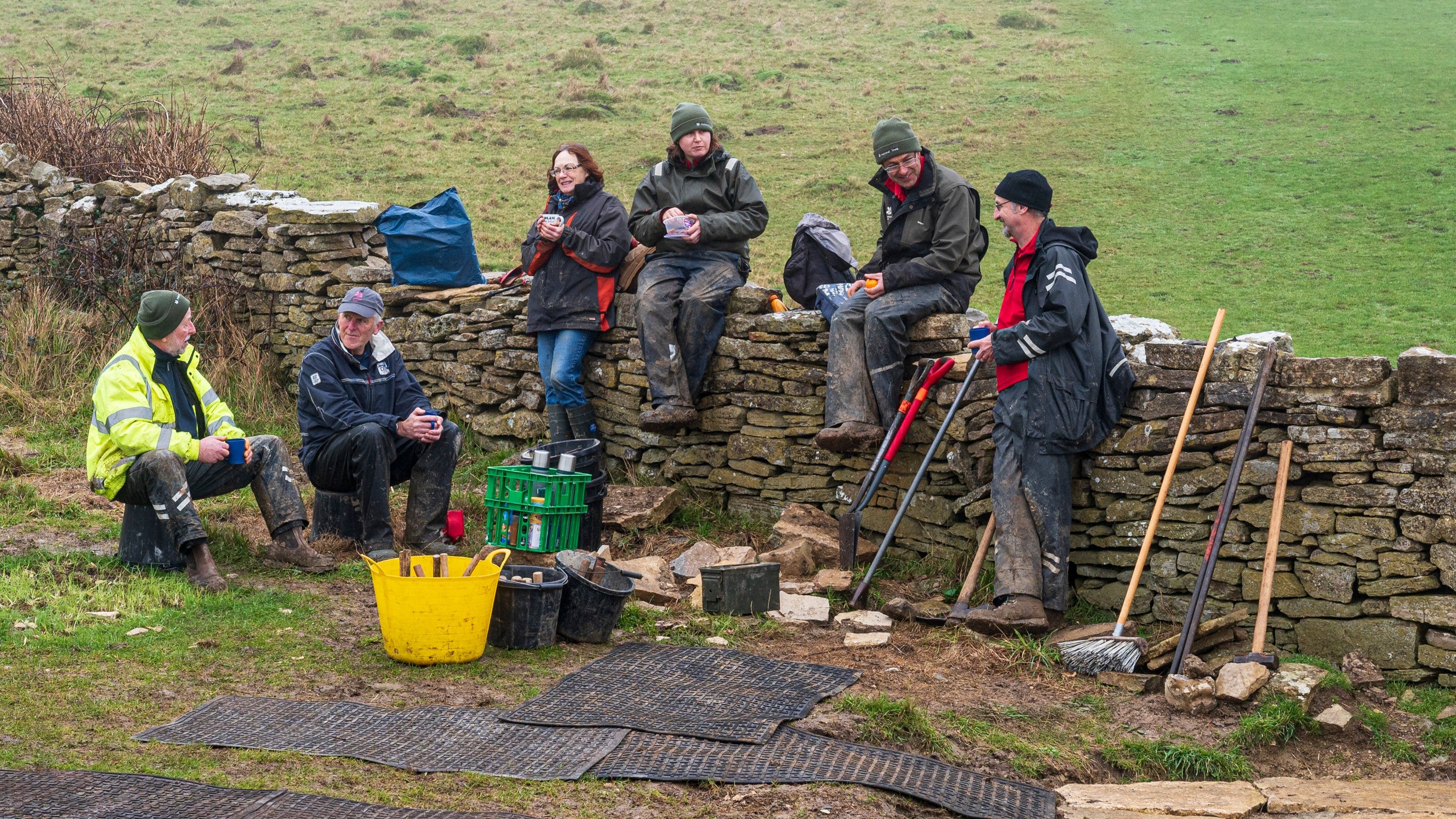 Volunteers enjoying a teabreak during a flagstone laying task at Spyway, Dorset