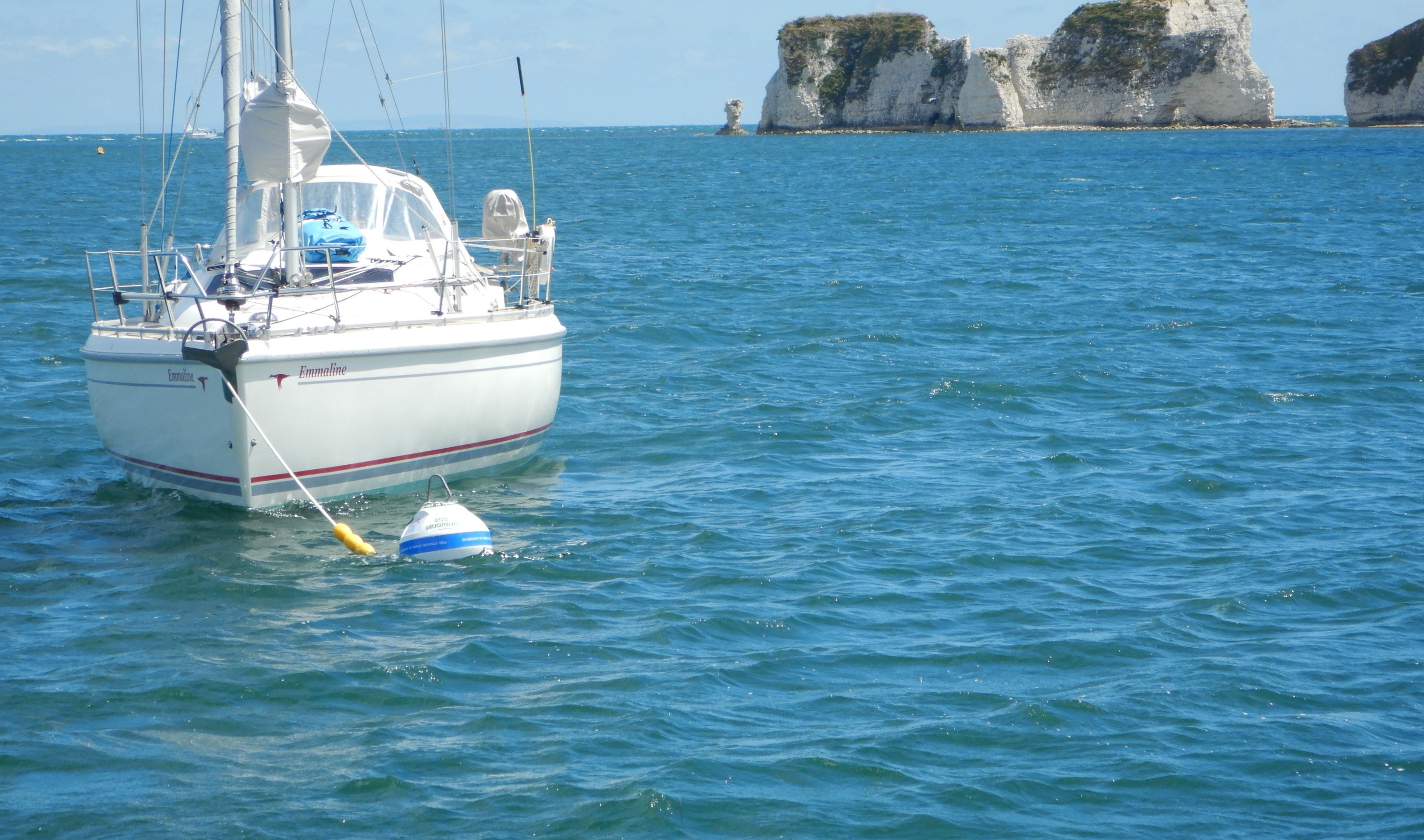 Yacht on eco-mooring with a view of Old Harry Rocks behind.