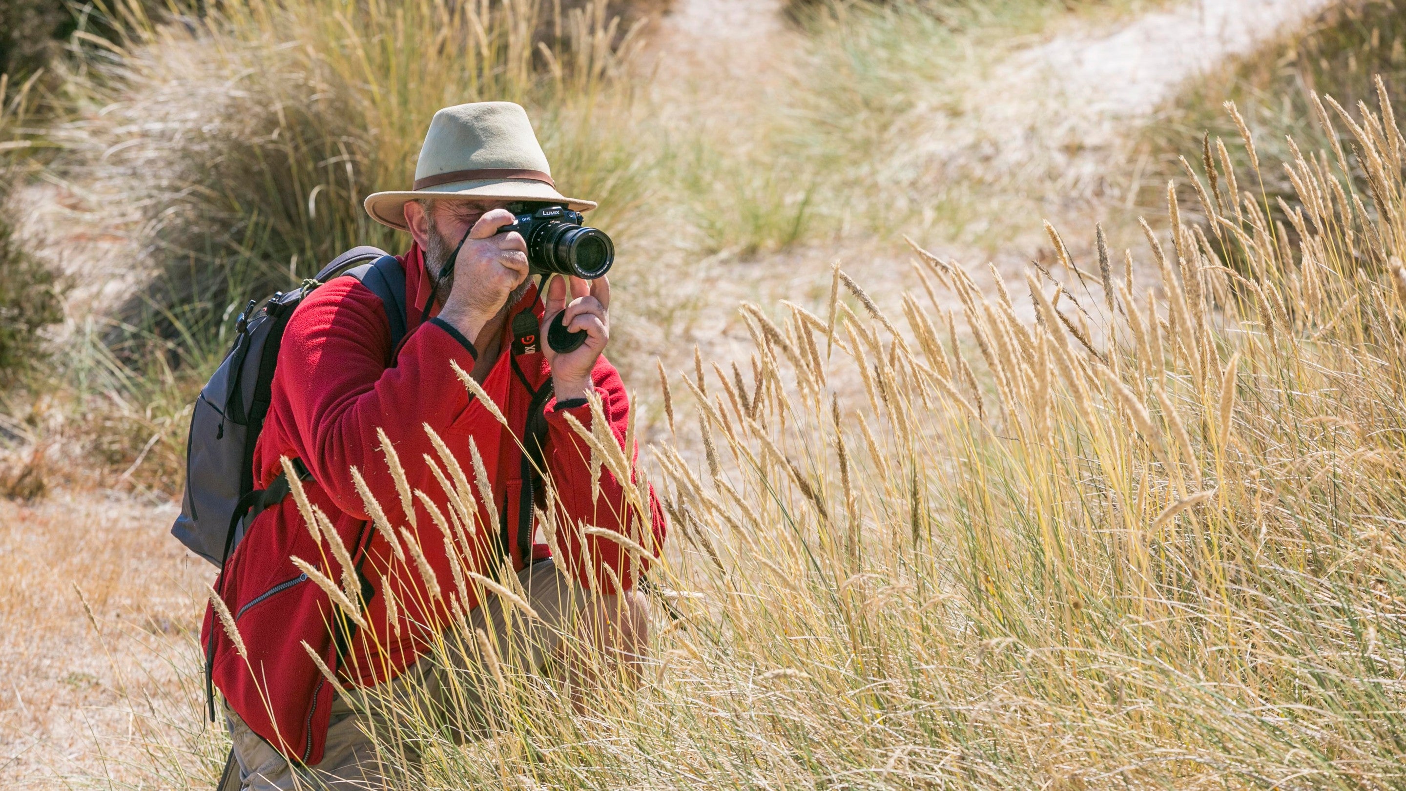 A visitor taking photographs at Studland Bay, Dorset