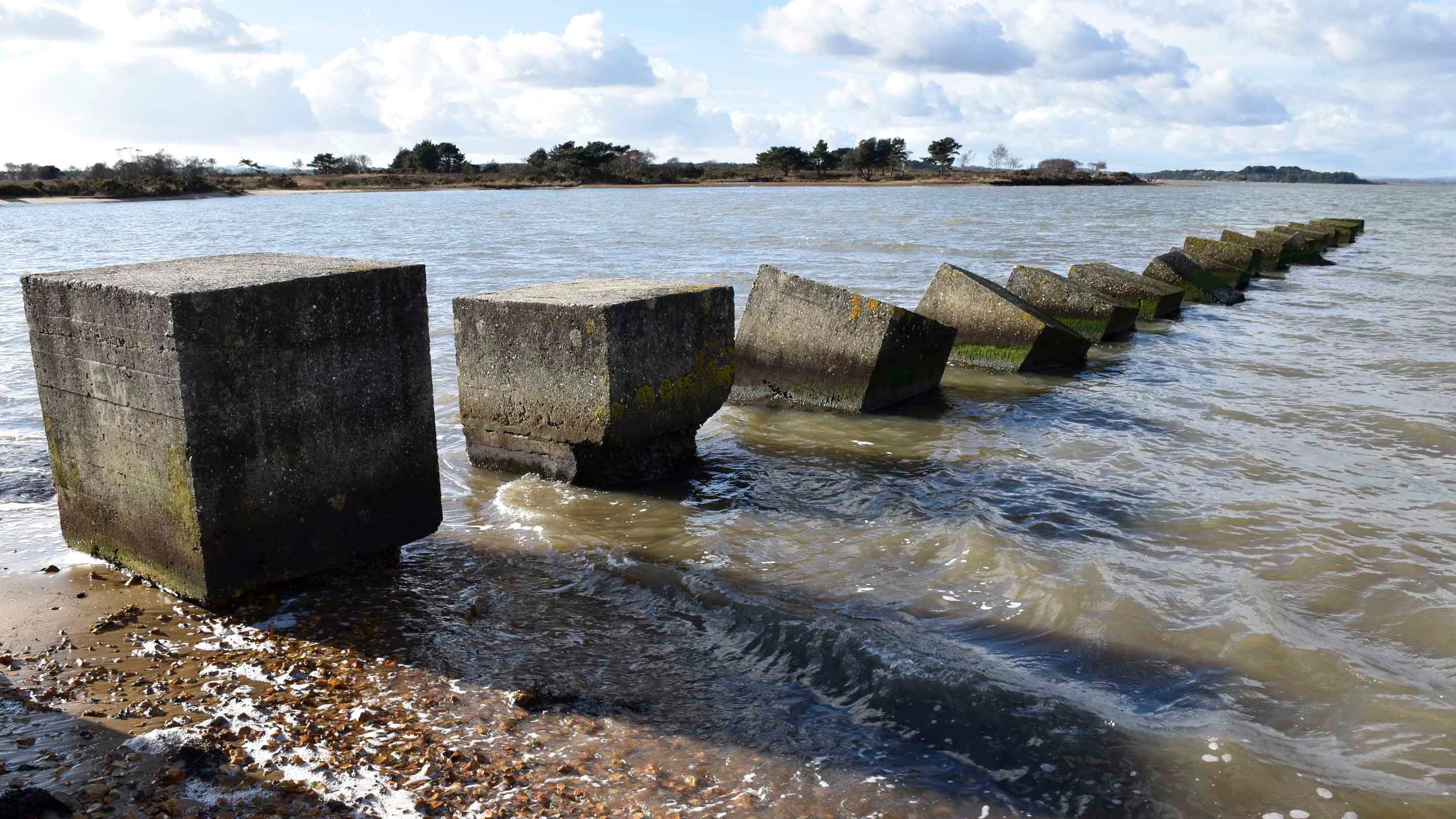 Second World War defences running into the sea at Studland Bay, Dorset