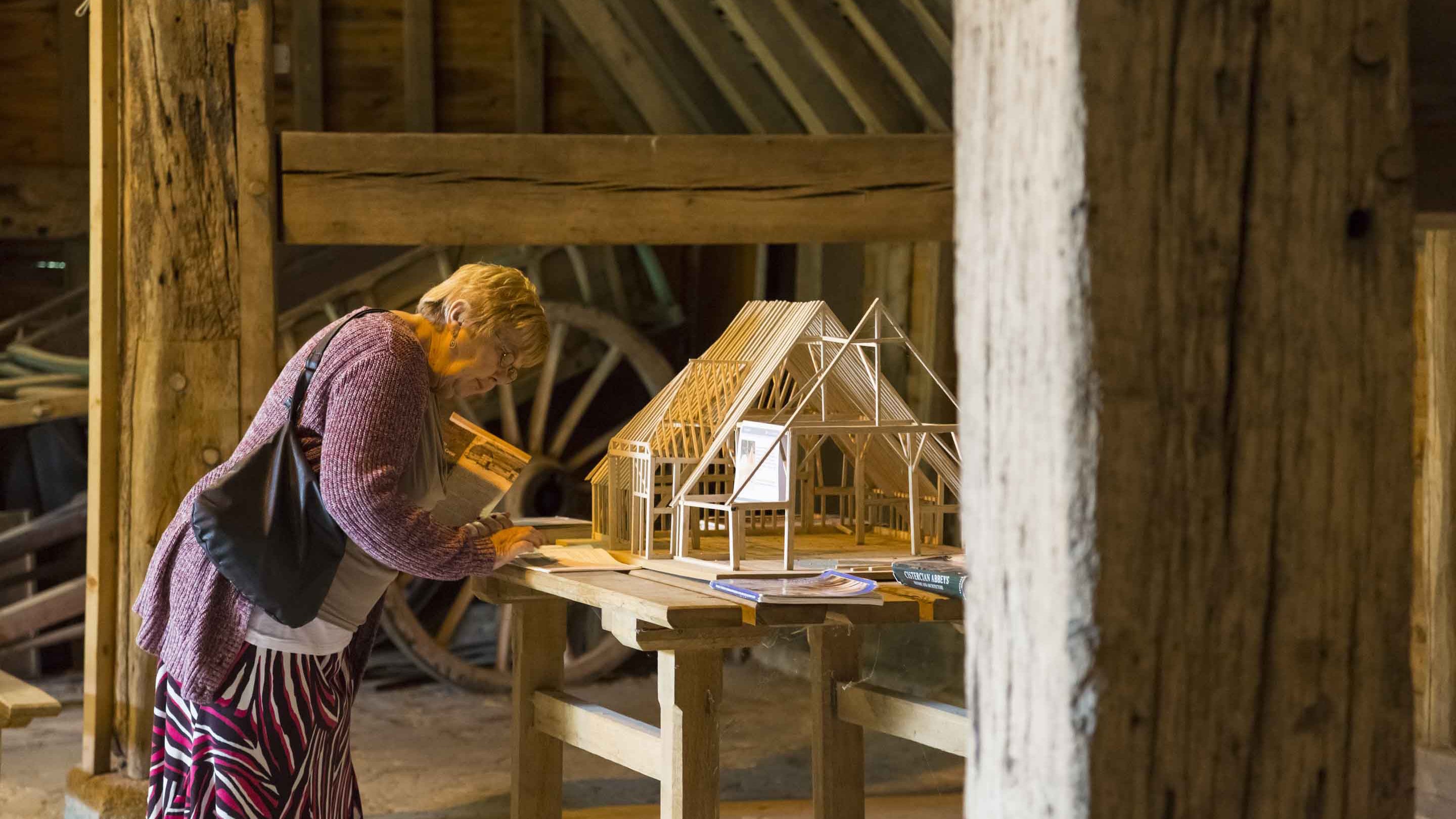 A visitor examining a model inside Grange Barn, Essex