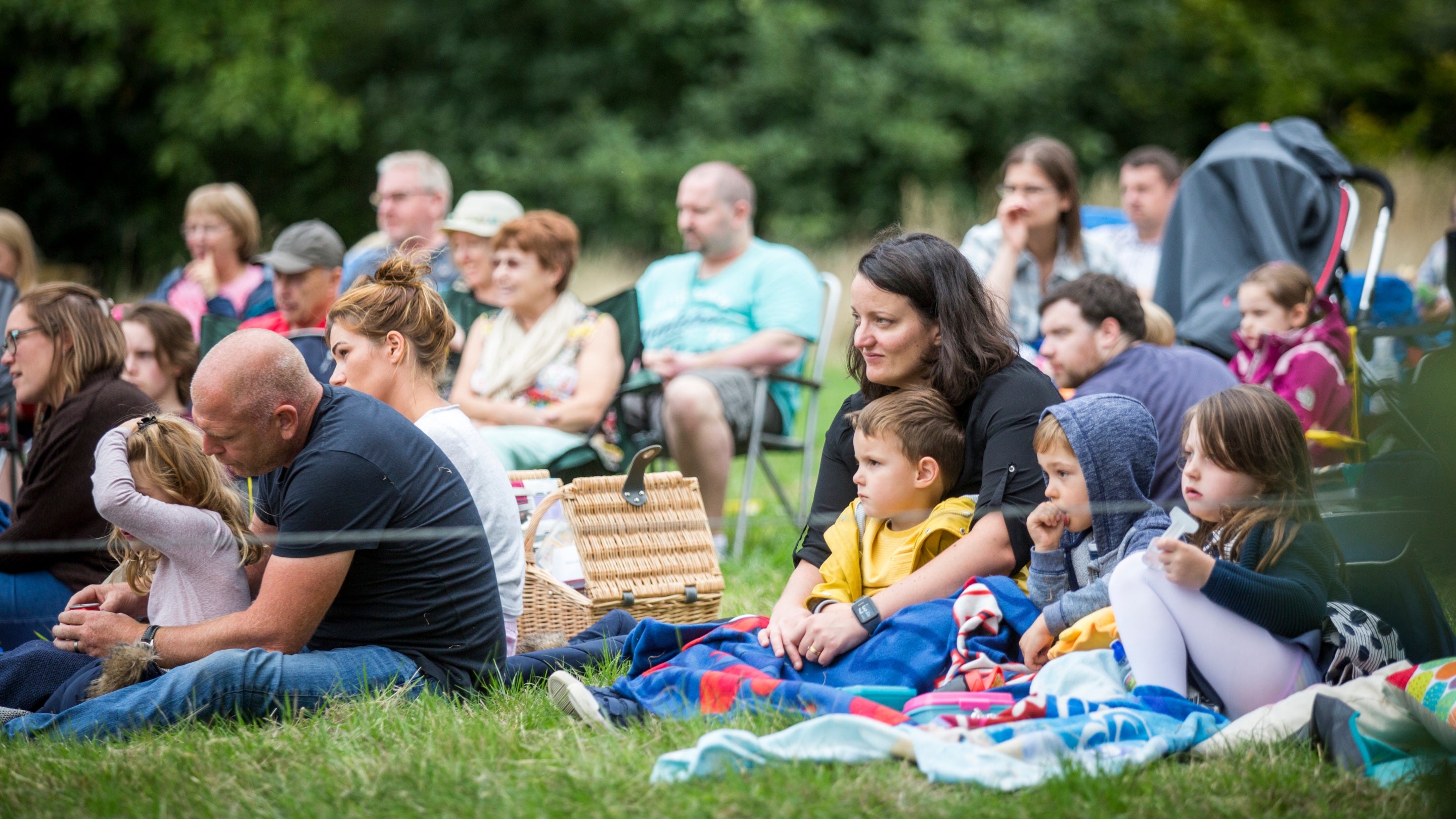 Families watching an open air theatre performance