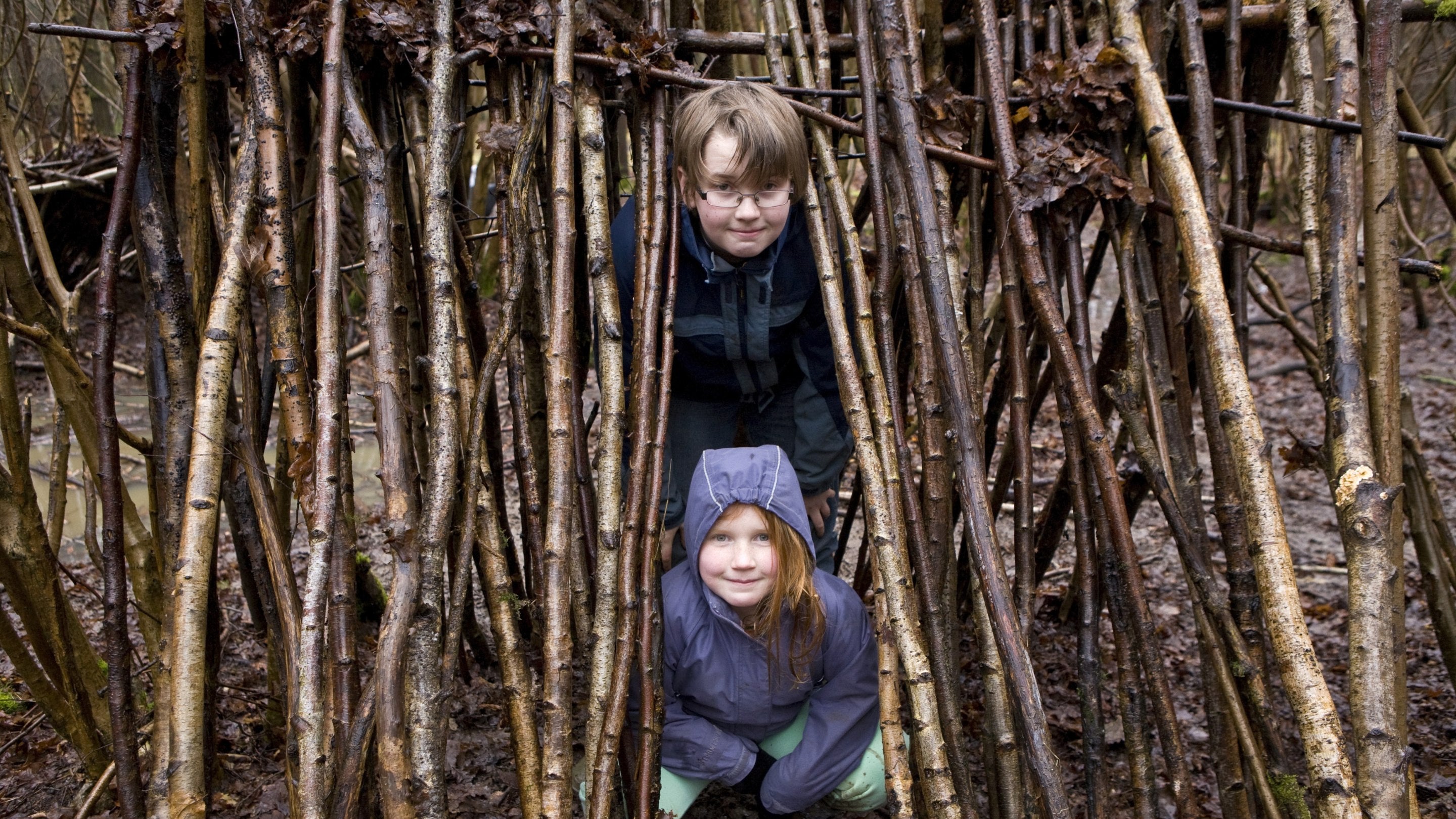Family learning how to build a shelter, filter water and light a fire on a forest survival skills course in Hatfield Forest, Essex. Family learning how to build a shelter, filter water and light a fire on a forest survival skills course in Hatfield Forest, Essex.