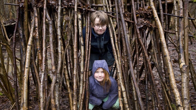 Family learning how to build a shelter, filter water and light a fire on a forest survival skills course in Hatfield Forest, Essex. Family learning how to build a shelter, filter water and light a fire on a forest survival skills course in Hatfield Forest, Essex.