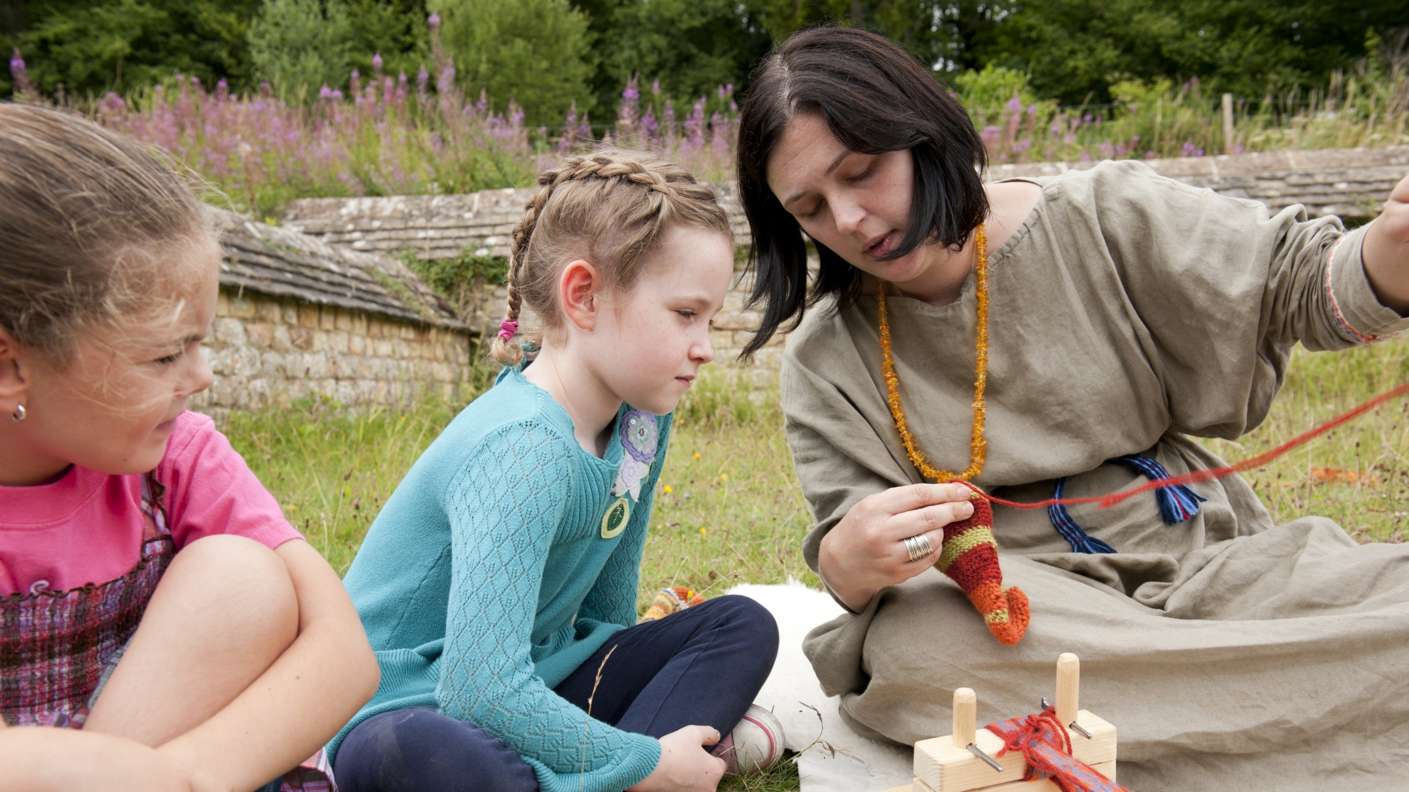Children learning about handweaving at Chedworth Roman Villa, Gloucestershire