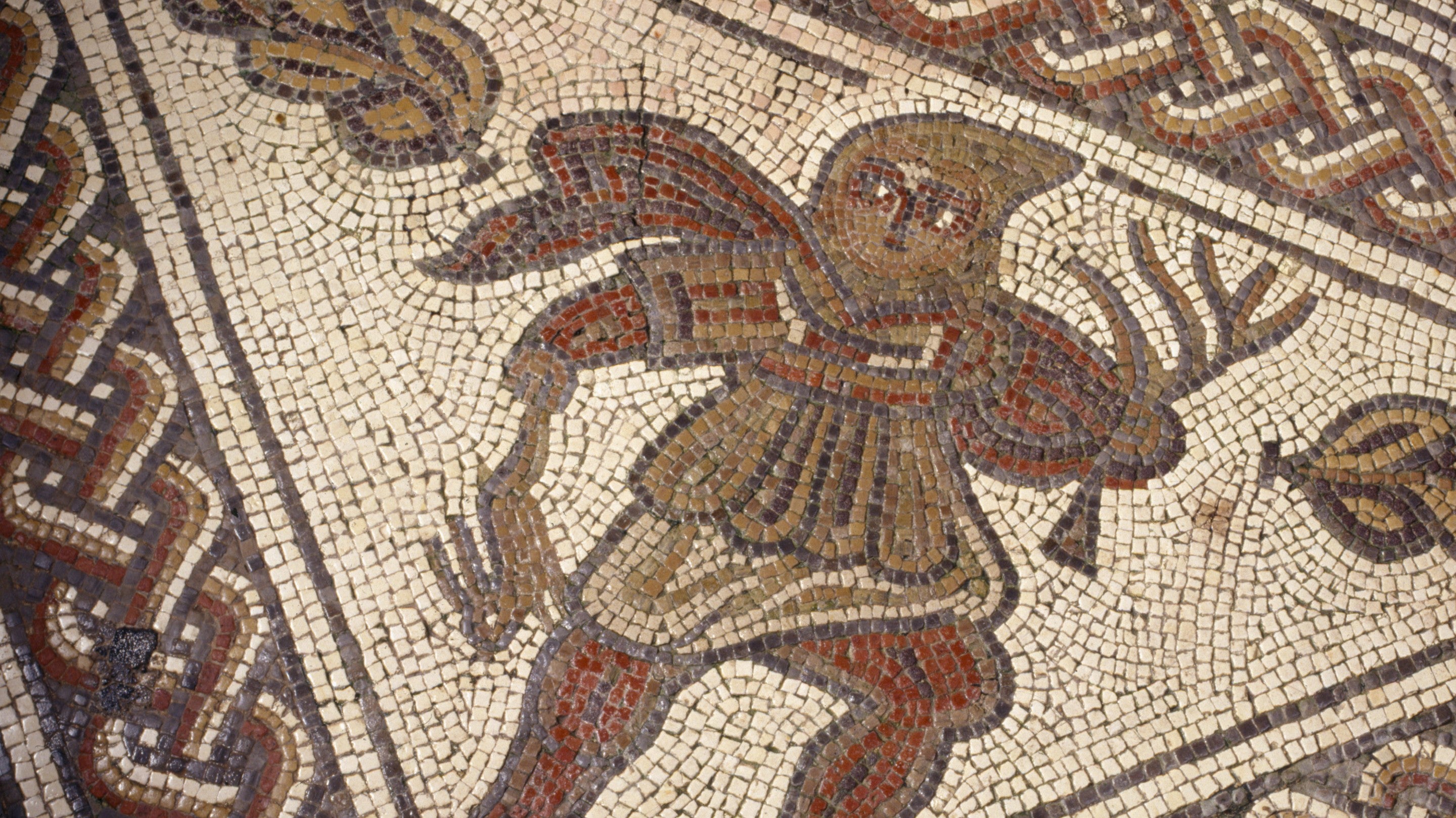 Close up of the mosaic in the Dining Room at Chedworth Roman Villa, showing the figure 'Winter' wearing a hooded cloak and holing a dead hare and a leafless branch, Gloucestershire