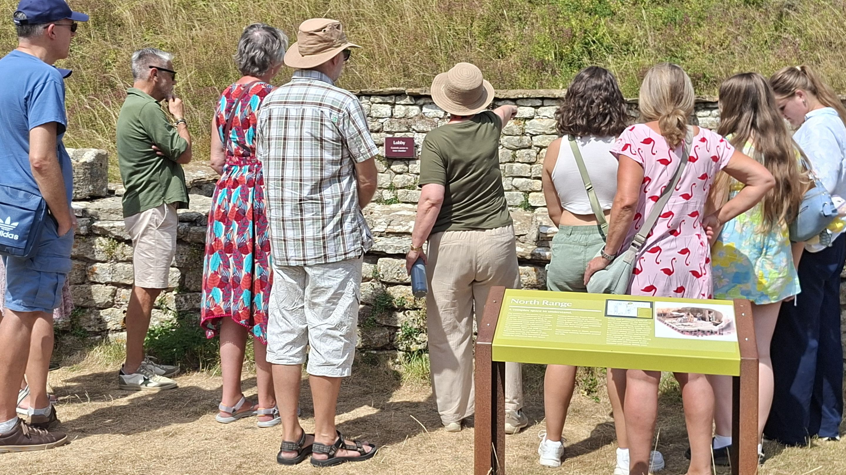 A volunteer site guide at Chedworth Roman Villa with a group of visitors