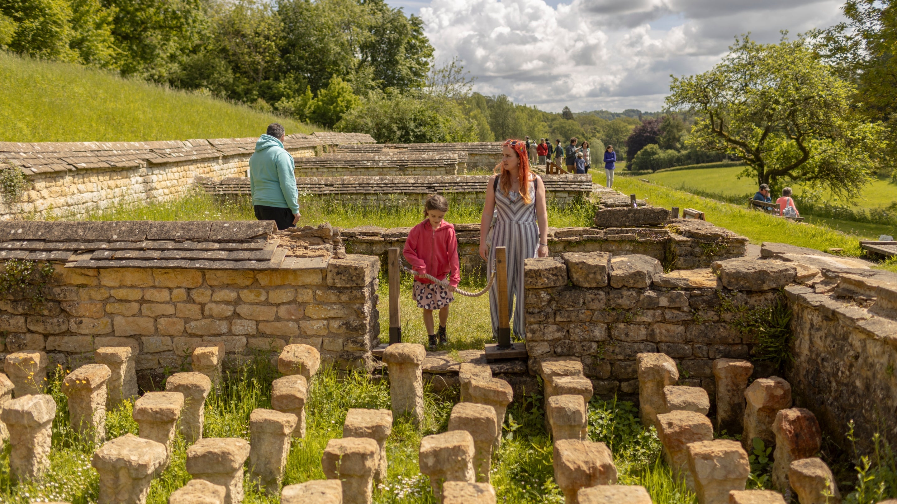 A parent and child looking at Roman ruins at Chedworth Roman Villa, Gloucestershire