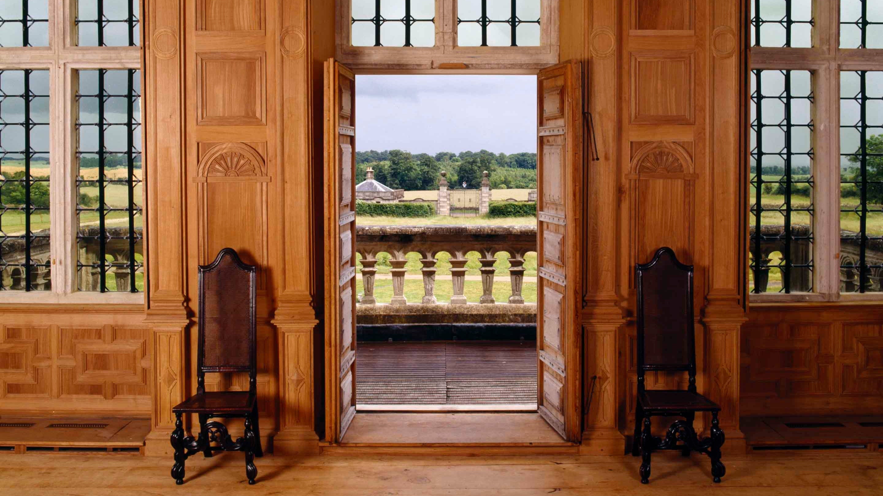 View from inside the Great Room looking out through open doors into the park at Lodge Park, Gloucestershire
