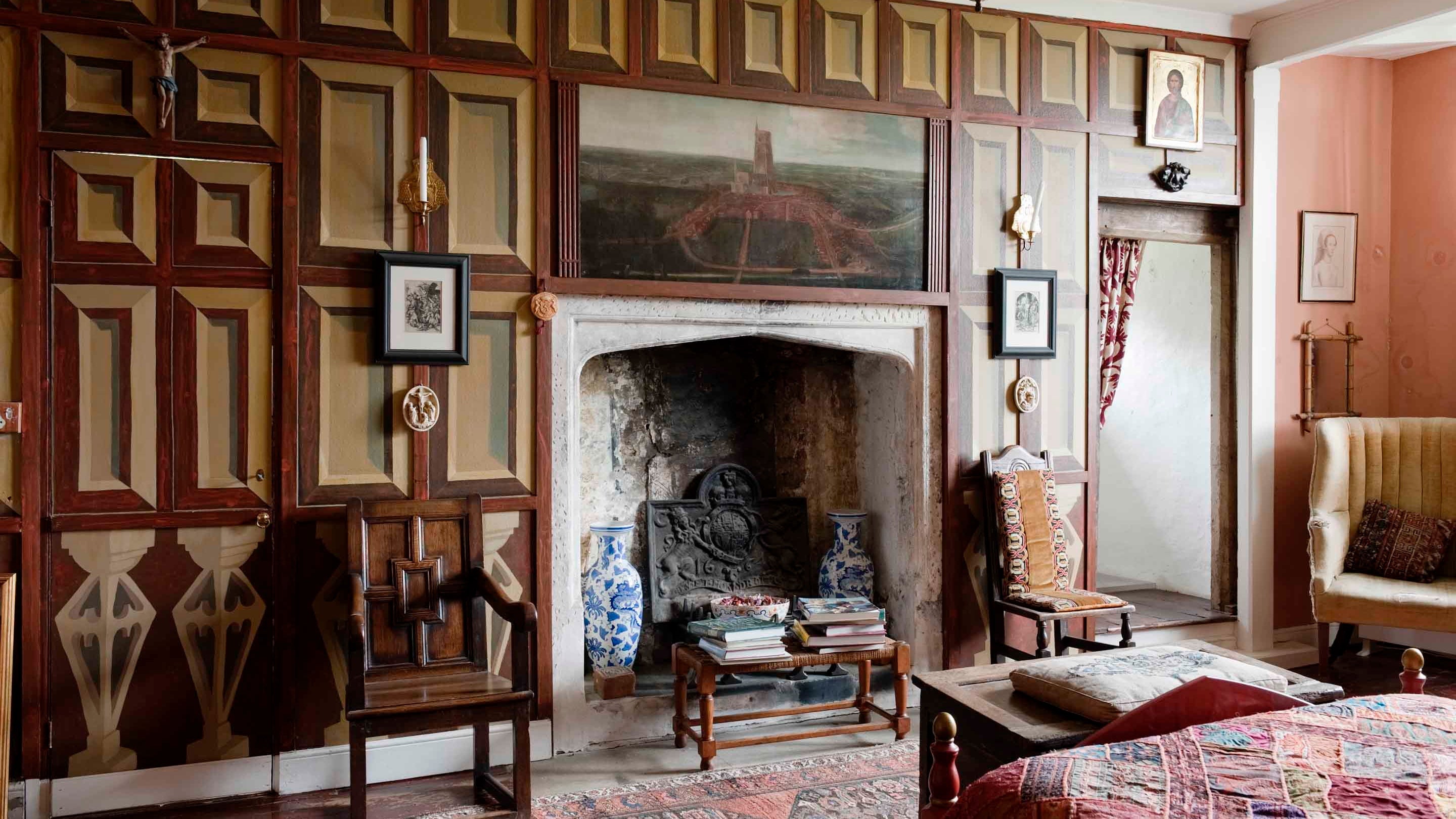 Wooden panelled wall with a big fireplace at Newark Park
