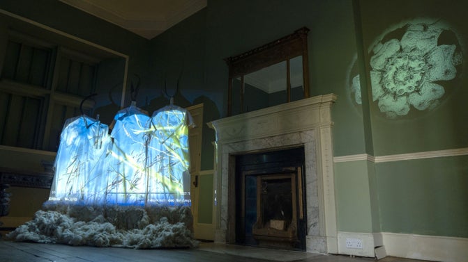 Audio-visual installation with sheep fleece at the foot of the figures