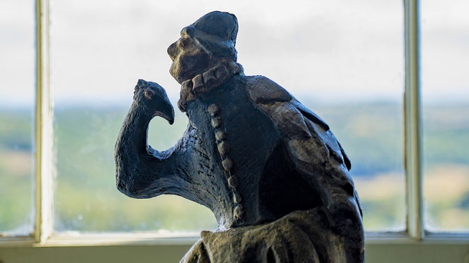 A ceramic figure of a Tudor with a peacock head for an arm