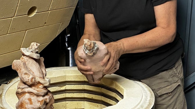 Woman's hands unloading kiln