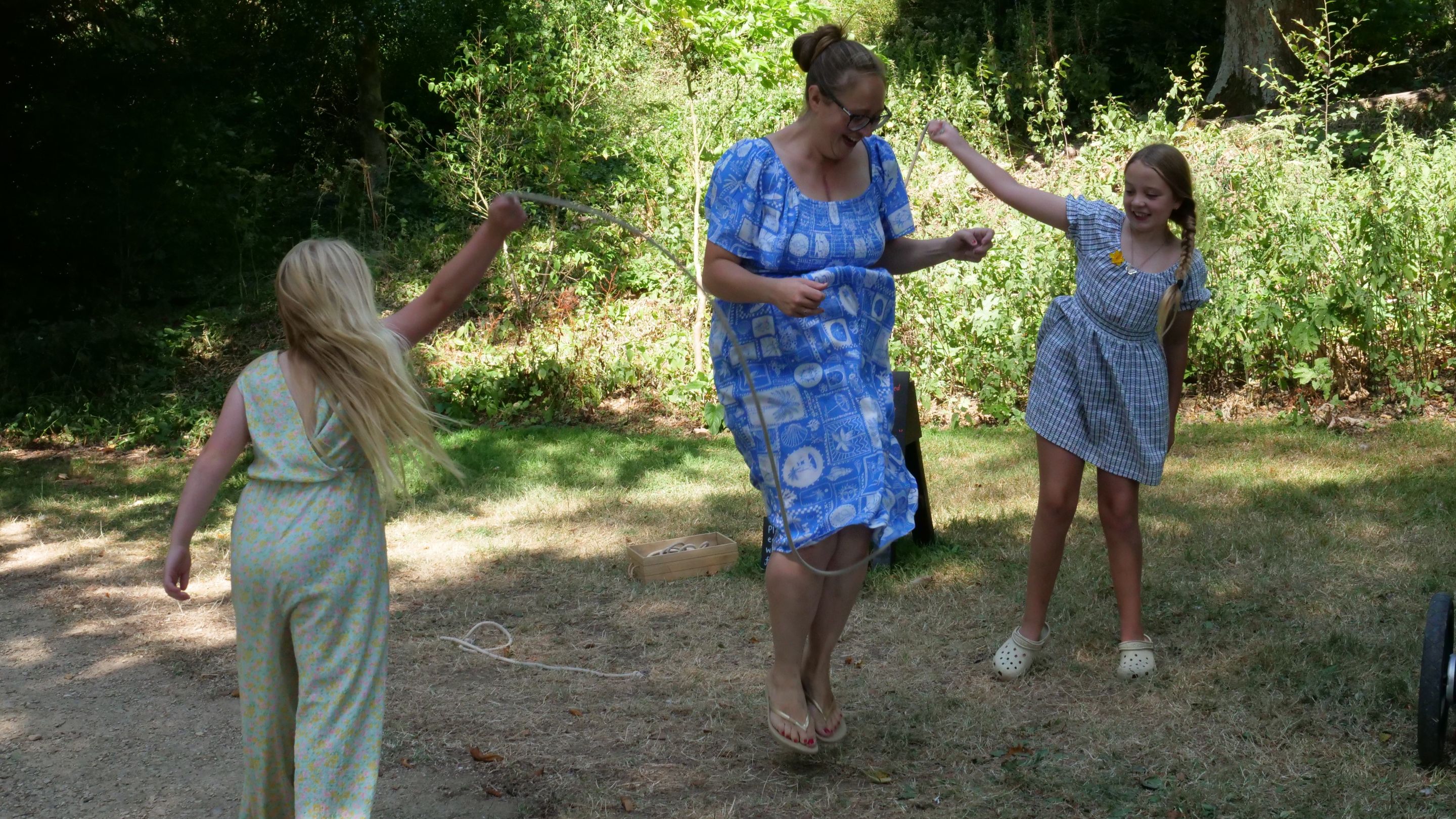 A family playing jump rope in a woodland setting